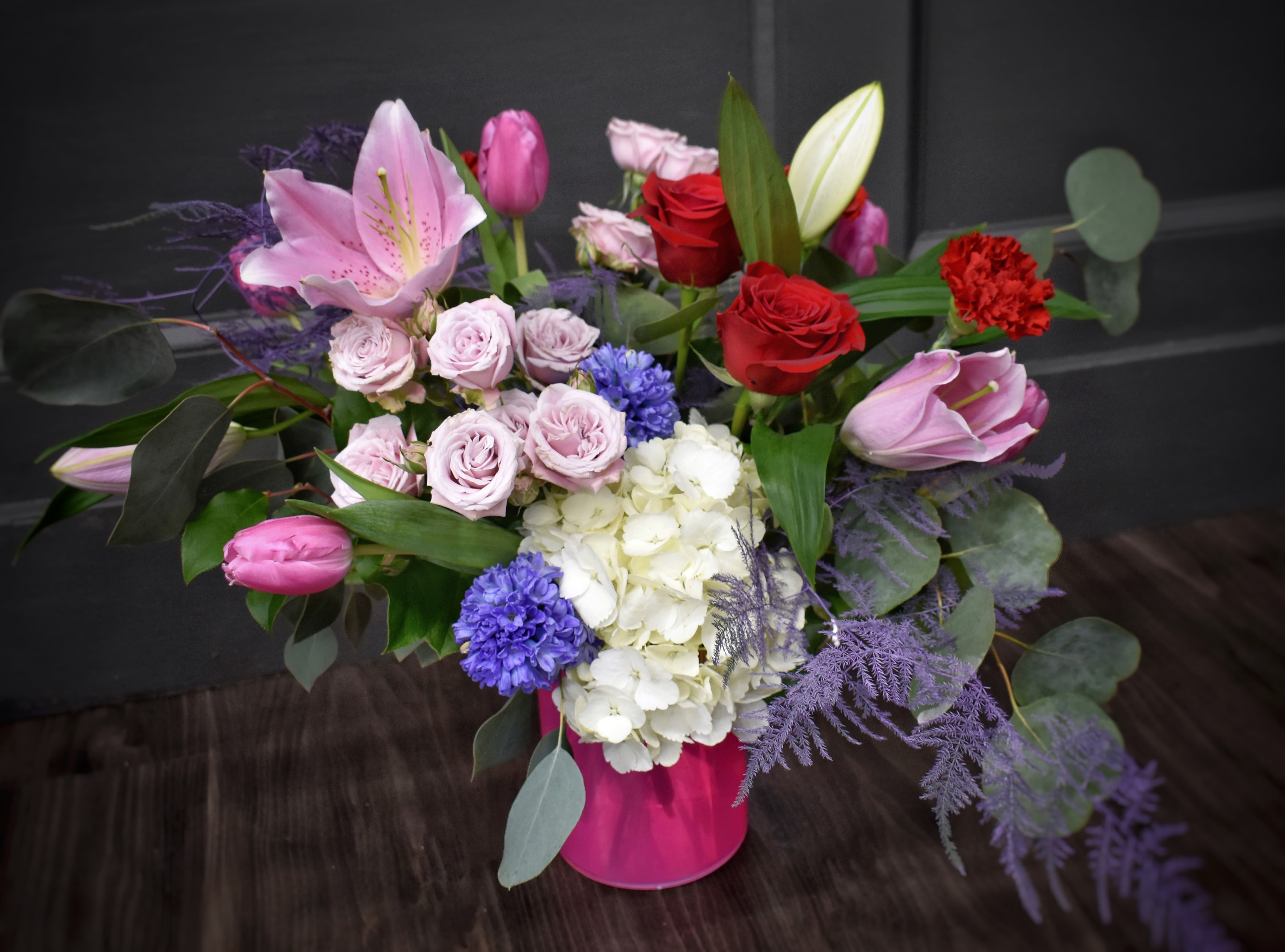Smitten  - Who are you smitten about? Today is the perfect day to give them the Smitten bouquet. Lovely pink lilies and purple hyacinth accompanied by pink tulips, red roses and more.