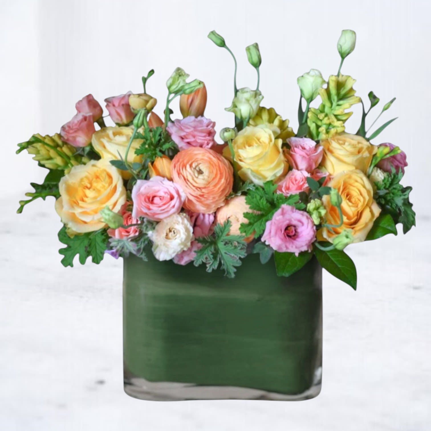 Market Day - Market Day is a lively mix of garden-inspired blooms in soft peach, butter yellow, and fresh pink tones. Designed with natural movement and layered texture, this arrangement brings together premium roses, ranunculus, lisianthus, and seasonal accents in a modern green glass vessel.  Cheerful without being loud and polished without feeling formal, Market Day is perfect for birthdays, thank-yous, hosting moments, or simply brightening your home for the week ahead.  Available for same-day flower delivery in Magnolia, The Woodlands, Spring, Conroe, and throughout the Greater Houston area. Flower varieties may vary seasonally while preserving the overall color palette and fullness of the design.