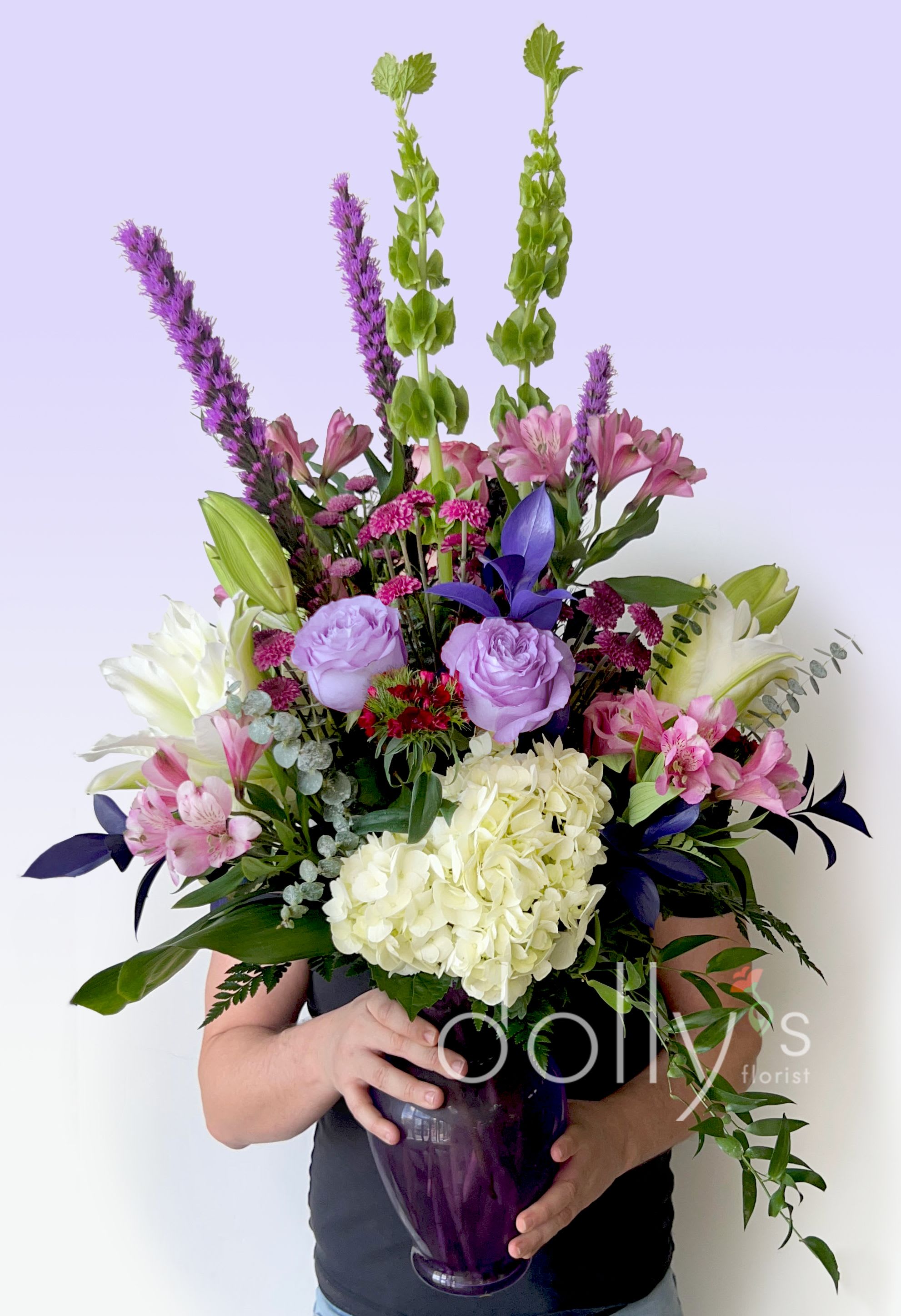 Purple Passion - Rich and elegant. A collection of purple and hot pink flowers composed in accompanying glass vase.