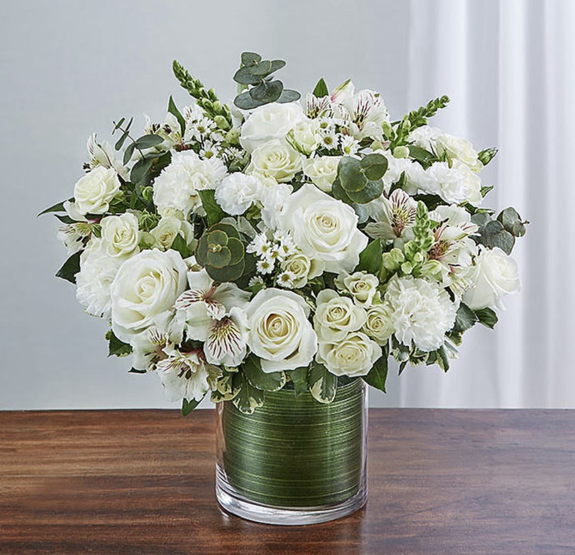 Beautiful Memories - Memories are timeless treasures of the heart, meant to be cherished. Our striking, all-white sympathy arrangement of roses, snapdragons, alstroemeria and more, elegantly designed by hand in a graceful cylinder vase.