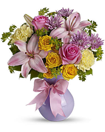 Perfectly Pastel - Impressionistic and impressive, this gorgeous bouquet of pastel flowers in a stunning lavender vase is a work of floral art. You know who would appreciate it. Surprise them. The elegant bouquet features pink Asiatic lilies, yellow carnations, lavender cushion spray chrysanthemums, yellow spray roses and pink roses accented with assorted greenery. Delivered in a lavender plastic vase tied with a pink satin ribbon. Orientation: All-Around
