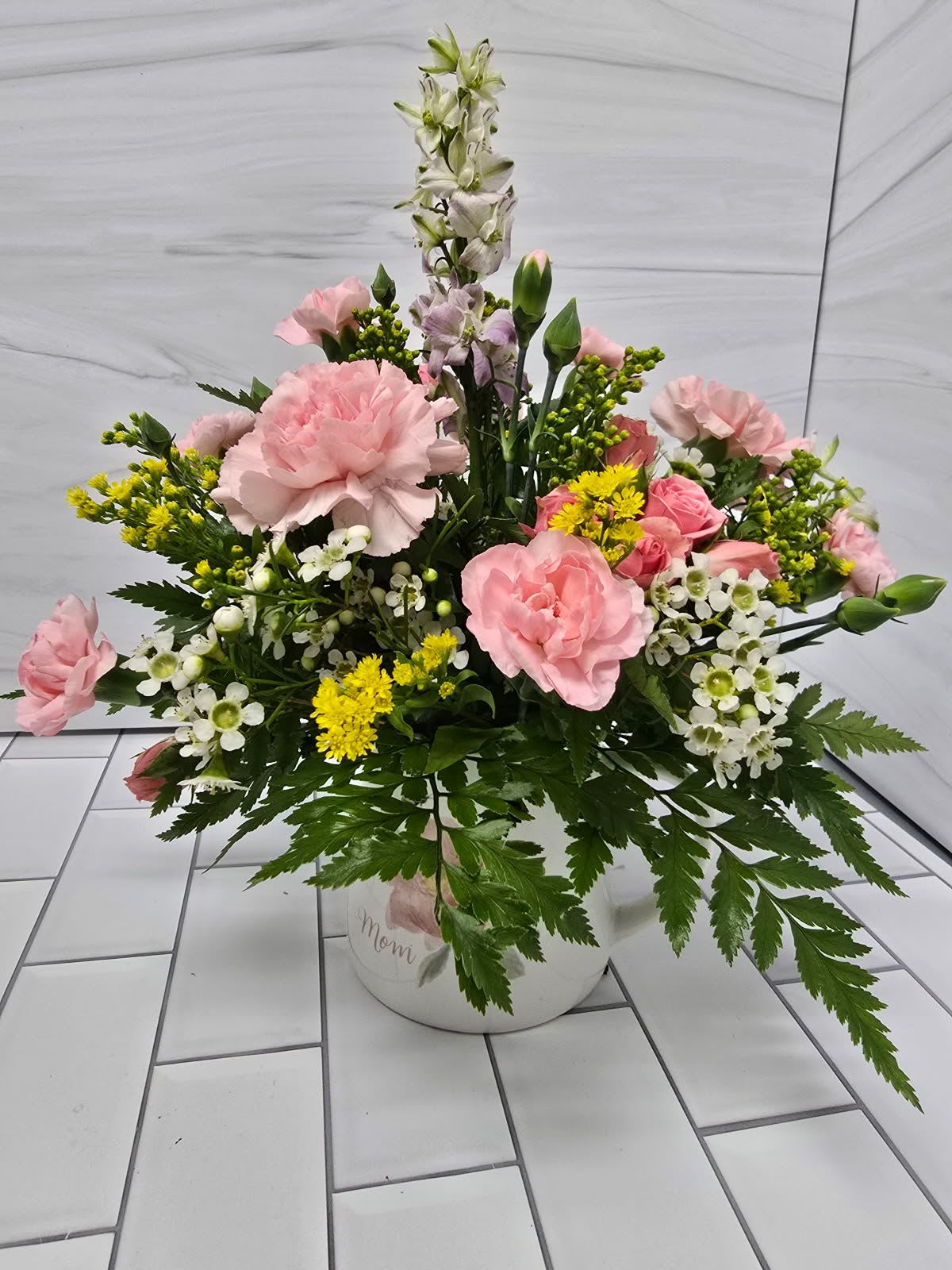 Pink Mug of Delight - A mug arrangement with light pink carnations, spray roses and larkspur.