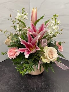 She's A Treasure - Show how much she means to you with our She's a Treasure Arrangement!  Mixed garden arrangement with roses, lilies, stock and carnations in a container for a sweet and feminine look.