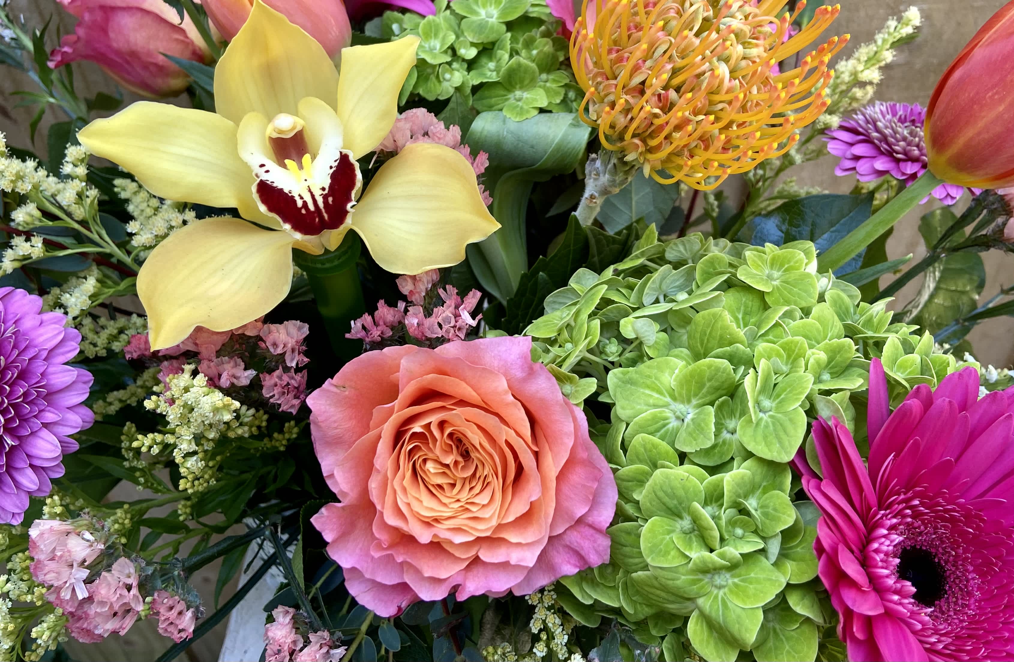 You Make Me Smile - From Free Spirit Roses, Hot Pink Gerber Daisies to Yellow Cymbidium Orchids and everything in between all nestled in a reusable ceramic container.. you'll definitely brighten their day!!!