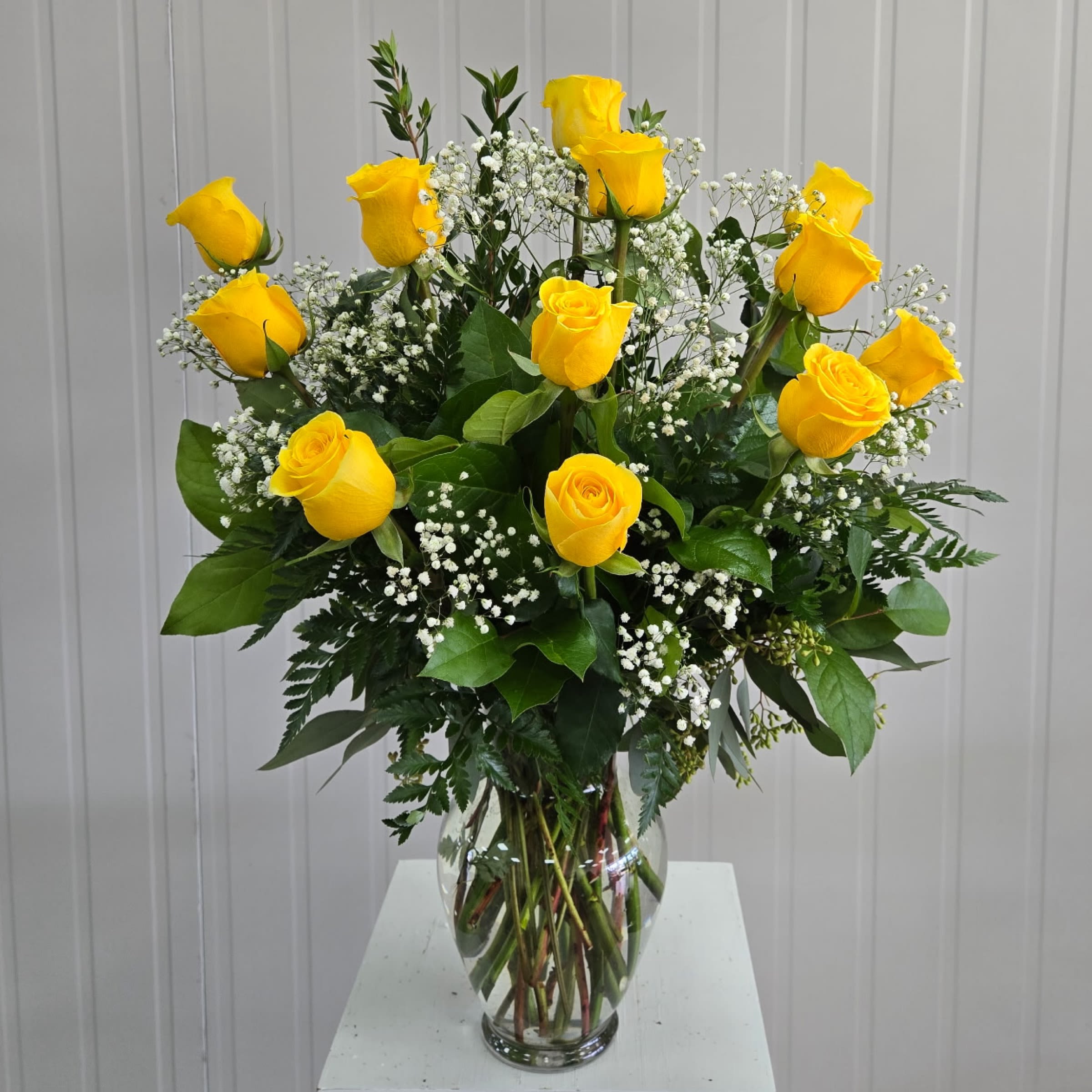 Classic Yellow Dozen - Yellow Dozen Roses with W/ Filler in a Glass Vase. Filler Flowers will be either Baby Breath or Wax flower.  Write in the Special Instructions if you have a preference Baby's Breath or Wax Flower.