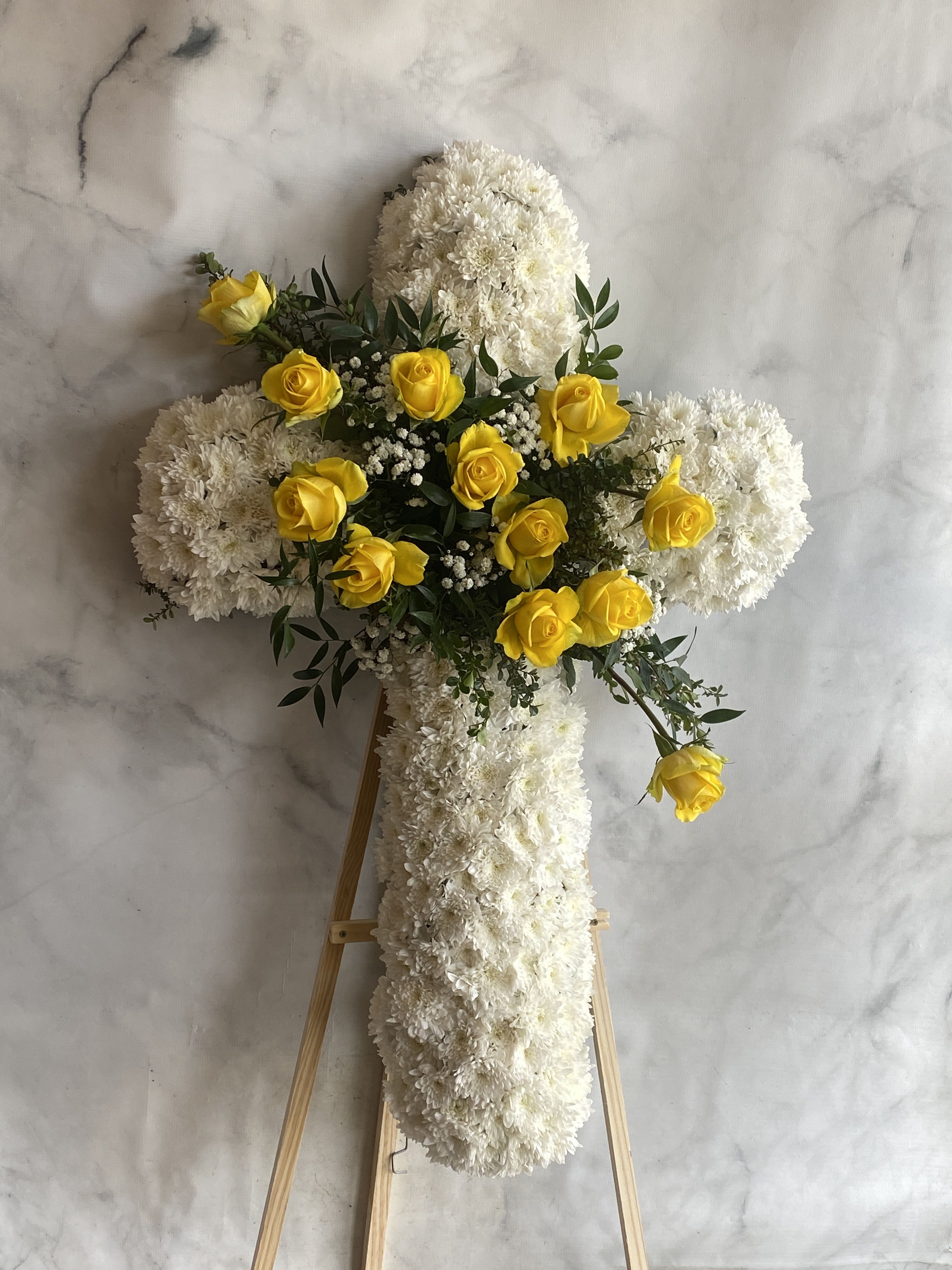 Sunrise Promise Cross - Our Funeral Cross Arrangement is a heartfelt tribute designed to honor and celebrate the memory of a loved one. Expertly crafted with fresh, premium blooms, this floral cross symbolizes faith, peace, and eternal love.  Available in three sizes to suit your needs: 30", 36" and 42"