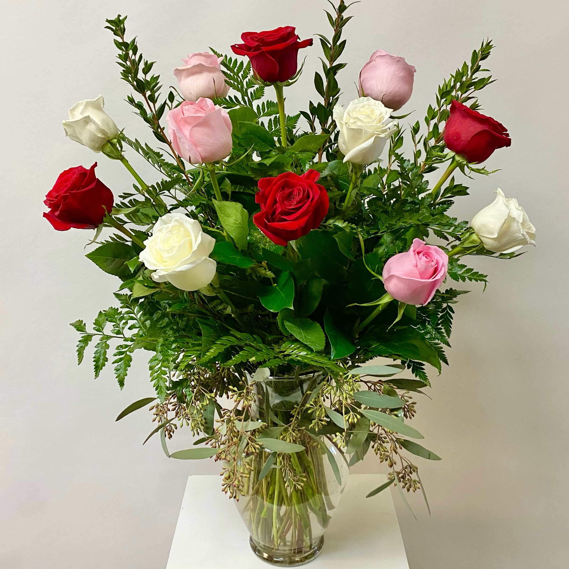 Dozen Romantic Roses - Dozen White, Light Pink and Red Roses with Greenery. Arranged in a Glass Vase.