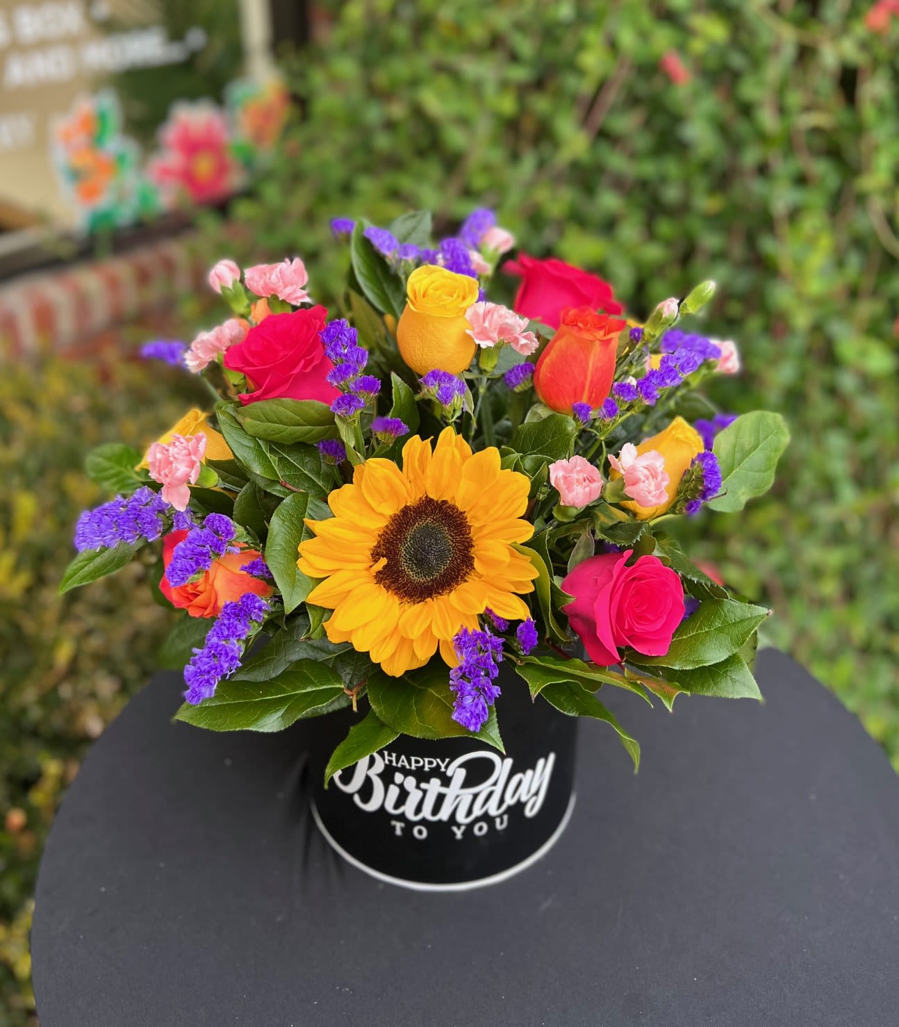 Celebrate in color  - A modern colored rose arragement features a sleek and stylish mix of roses in bold and soft tones - such as pink, yellow, purple and orange in a personalized luxury box.