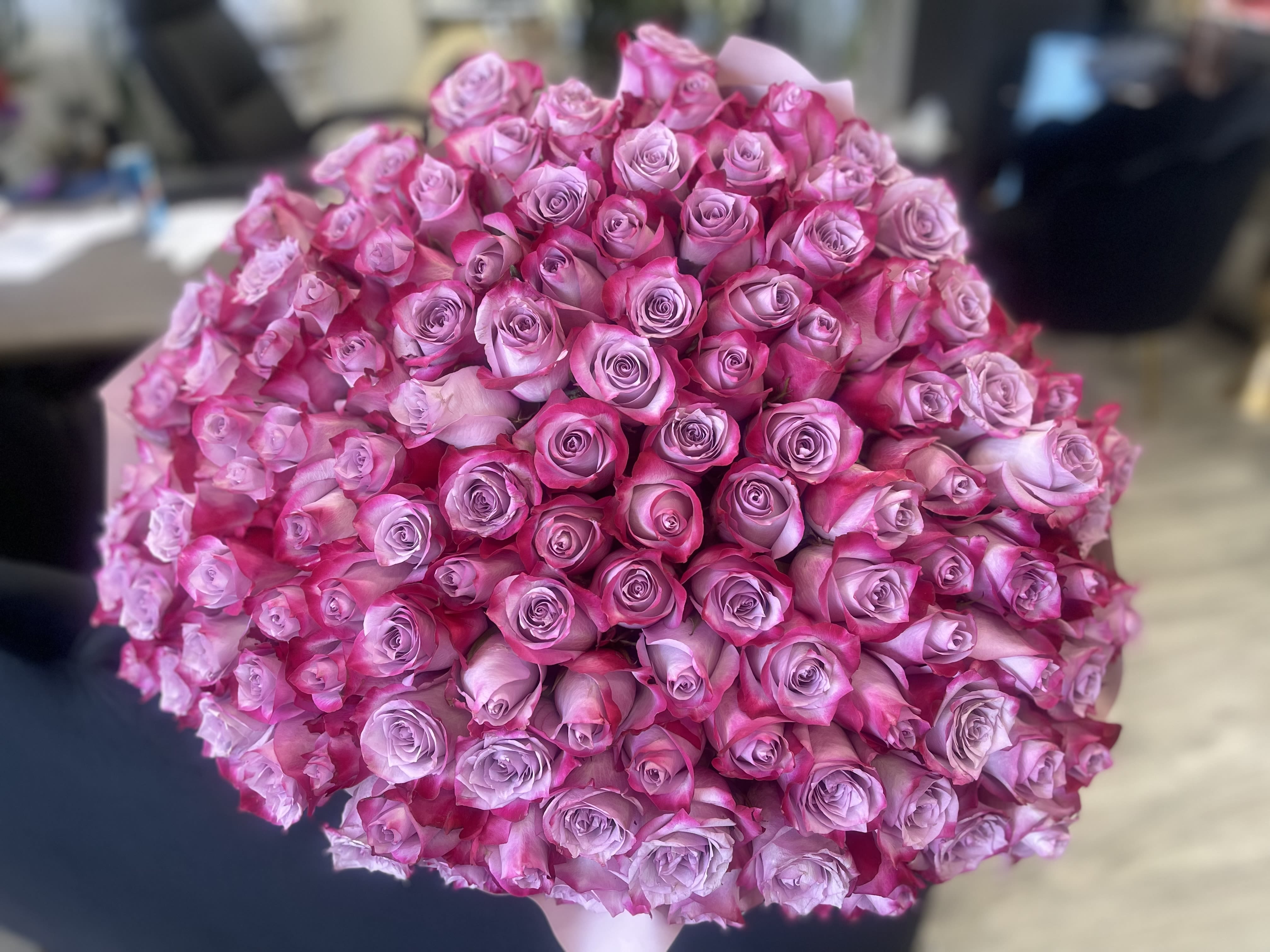 100 Bright Pink Rose Boquet  - Bold, vibrant, and unforgettable. Bright Pink Elegance features a stunning dome of premium bright pink roses with soft lavender centers. Tightly arranged for a full, luxurious look, this statement bouquet radiates romance, confidence, and celebration.  Finished with matching satin ribbon.  Available: Deluxe: 150 stems Premium: 200 stems    Some florals are seasonal, if a particular flower will not be available due to season, we will substitute for similar flower, composition, color pallet and value of the arrangements as closely as possible. All effort to create a floral arrangement as close to the photo shown, the actual arrangement may vary slightly in its appearance from the photo shown. If you have any questions about your order, we welcome you to call us in or email    Holiday Delivery:  Same-day delivery available. Deliveries are made throughout the day based on routing.    