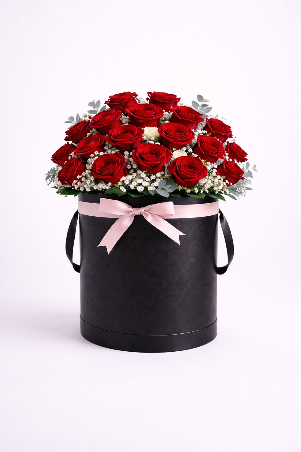 Classic Red Rose Hatbox – Tall - This elegant arrangement features 24 red roses, designed in a tall black hatbox and finished with delicate white accents and a soft blush ribbon. A timeless floral gift, perfect for celebrating love and meaningful moments.  Better For: Mother’s Day, Women’s Day, Anniversary, Birthday, Just Because  Each piece is Designer’s Choice, created with fresh seasonal blooms. Flowers and colors may vary based on availability while maintaining the overall style and quality. 