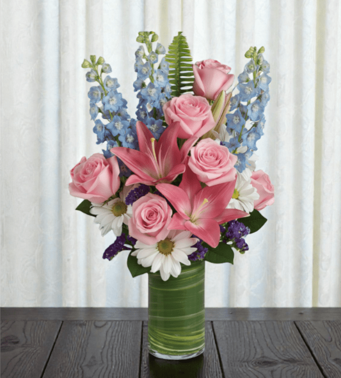 Blushing Bayou  - Beautiful blue delphinium, blush roses and delicate daisies make this arrangement sure to wow your loved one! 