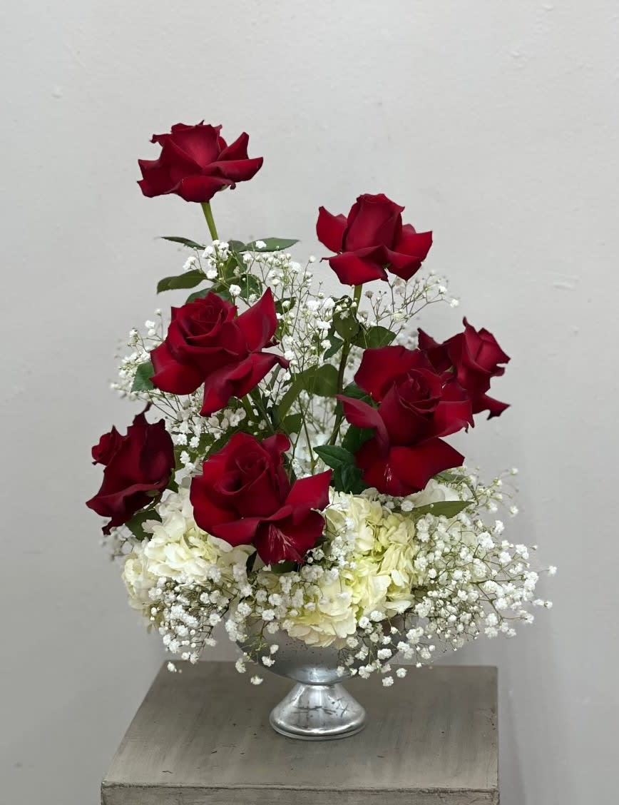 Love Is In The Air - Beautiful Long Stemmed Red Roses with cloudy white hydrangeas, babies breath, and filler in a silver mercury glass keepsake bowl.   STANDARD - 7 Roses DELUXE - 14 Roses PREMIUM - 19 Roses