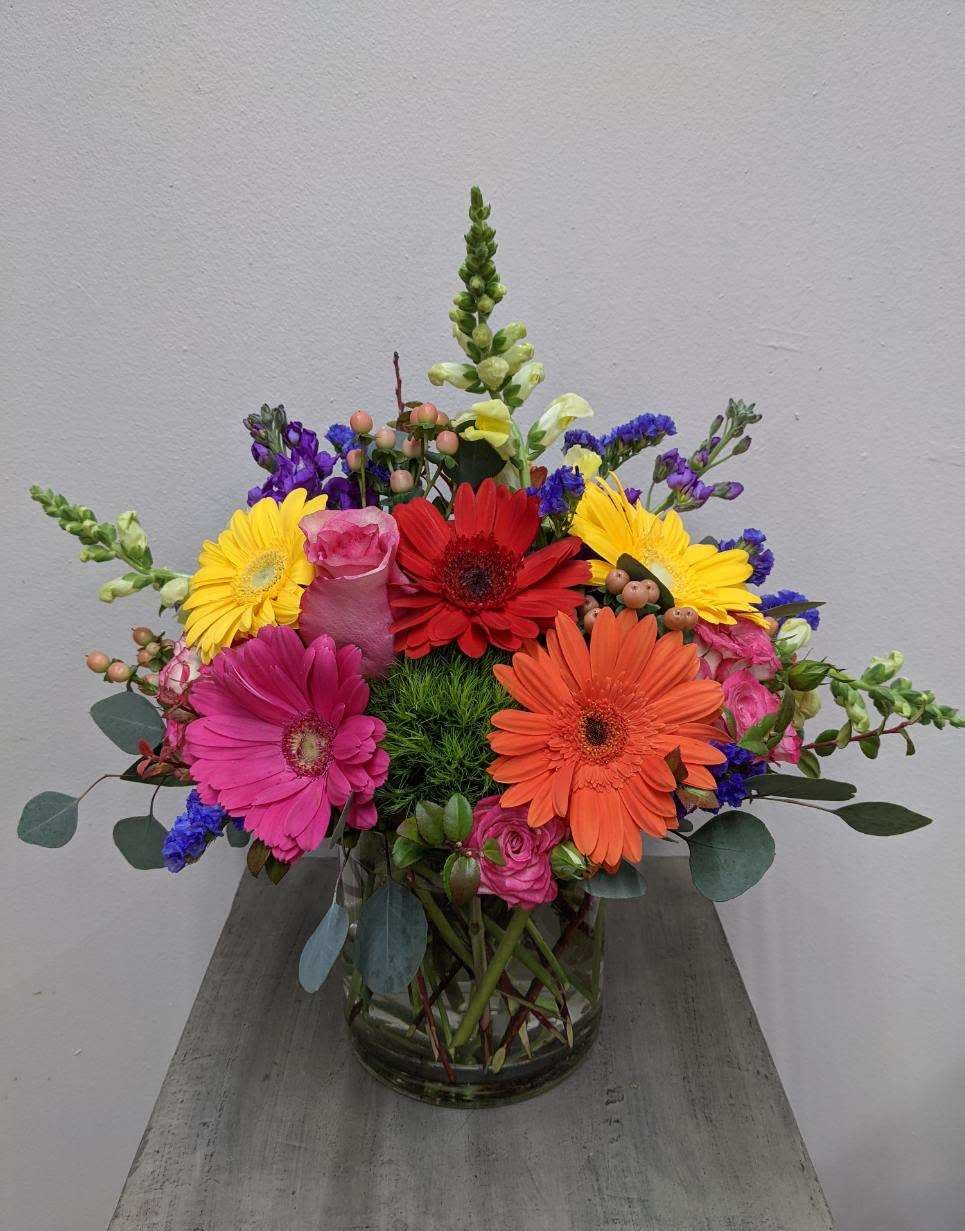 Gerberas and More Bouquet - Bright mixture of gerber daisies and other flowers such as roses and snapdragons, designed in a short cylinder vase.