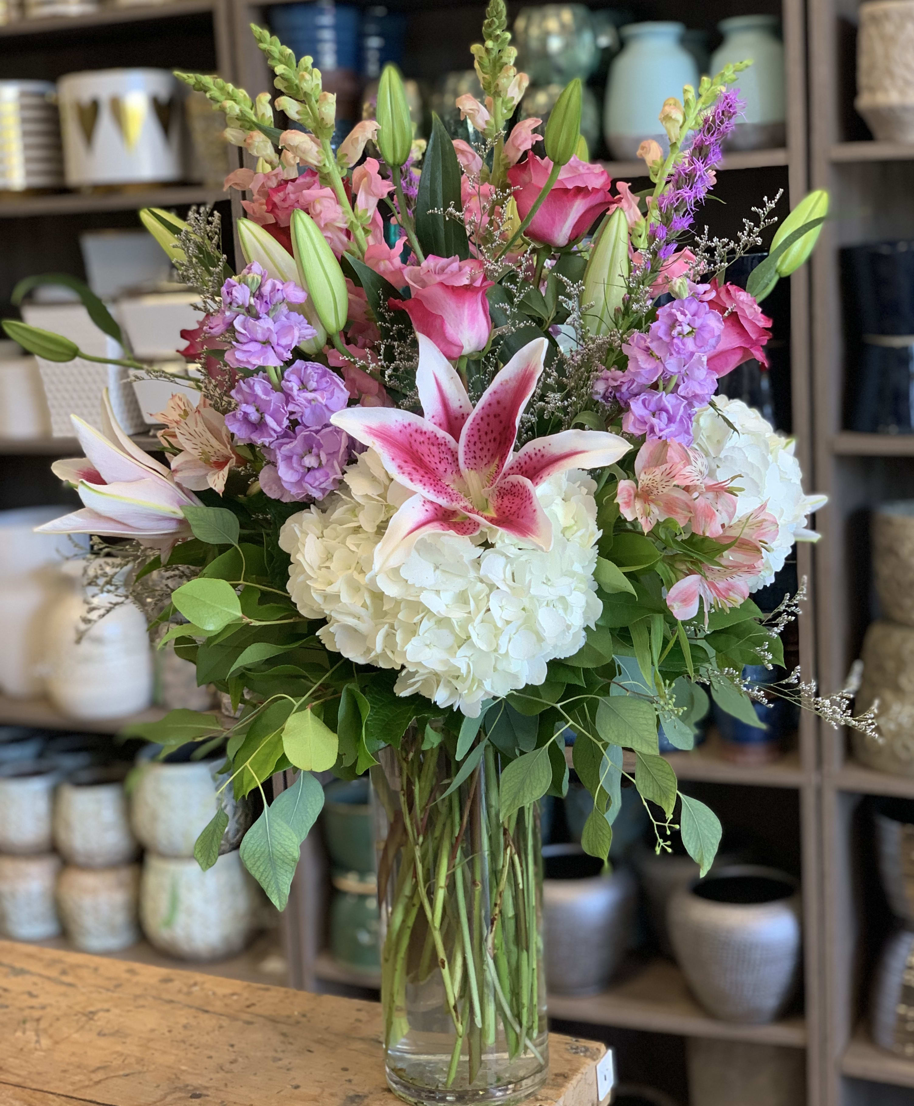 Circle of Love  - A stunning tall and airy arrangement featuring a graceful blend of roses, fragrant stargazer lilies, lush hydrangeas, delicate stock, and elegant snapdragons. This beautiful design exudes sophistication and freshness, perfect for adding a touch of elegance to any space.  