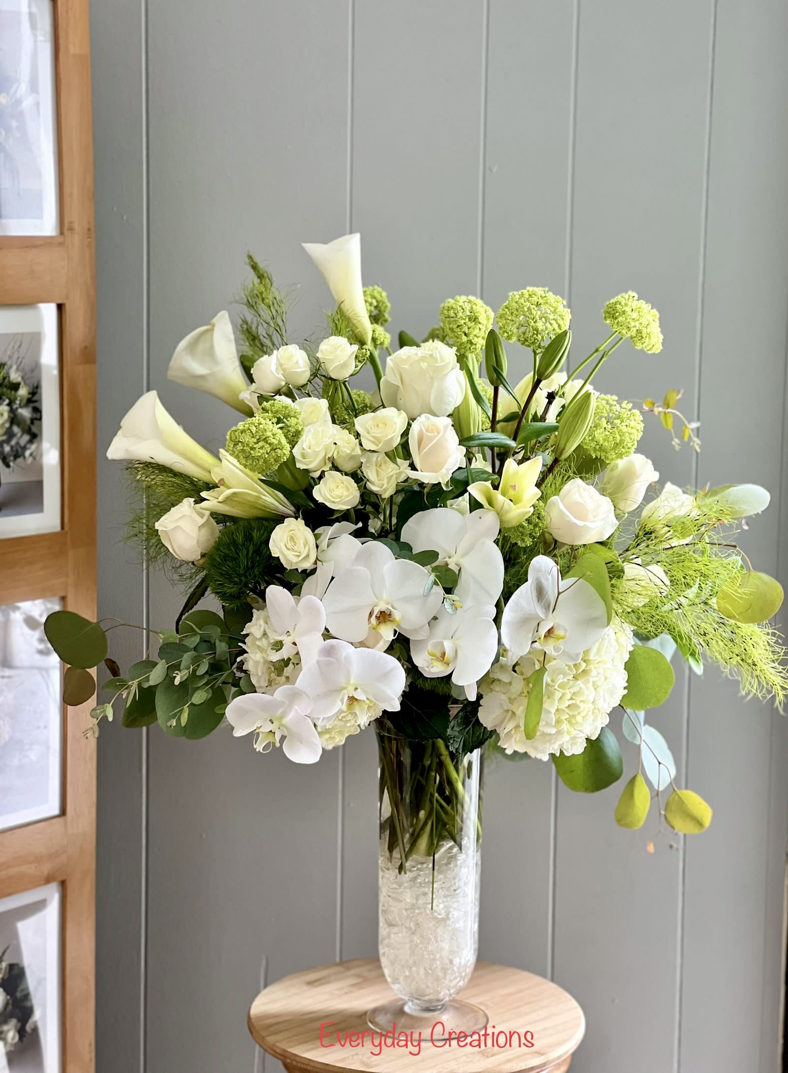 EC91 - Pure Elegance - This luxurious design features a graceful blend of pristine white Phalaenopsis orchids, white roses, green hydrangeas, and elegant white calla lilies, all artfully arranged in a tall, clear glass vase. Soft green accents, including lush foliage and seasonal greenery, complete the design, creating a sophisticated and timeless look perfect for any occasion. Whether you're sending flowers for a birthday, anniversary, sympathy, thank-you, or as a beautiful home or office display, this white and green arrangement brings freshness and elegance to any space. Order now for same-day flower delivery in Tustin and surrounding Orange County areas, including Irvine, Santa Ana, Orange, and Costa Mesa. Trust your local Tustin florist for premium flowers and exceptional service.Make a lasting impression with our Elegant White and Green Floral Arrangement, expertly designed by our local florists in Tustin, CA  