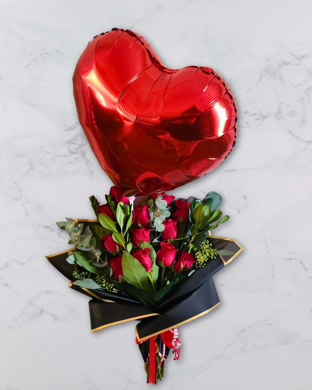 Corazón de Mi Alma Ramo by Latin Lady Luxe - Corazón de mi alma is a soft, romantic bouquet designed to express love with elegance and warmth. A Valentine’s‑themed, air‑filled balloon peeks gently from within the blooms, adding a sweet touch without overwhelming the arrangement.  White lilies, pink snapdragons, red baby’s breath, and fresh eucalyptus are arranged in a lush, full silhouette and wrapped in layered Korean‑style paper with a satin ribbon. This bouquet is perfect for anniversaries, celebrations, heartfelt surprises, or simply reminding someone how much they mean to you.  ---  Disclaimer  This arrangement includes baby’s breath that has been painted red. Painted florals may naturally carry a light odor that some individuals find unpleasant. If you prefer your bouquet without painted elements or have questions before ordering, please contact us — we’re happy to help.  All sales are final.