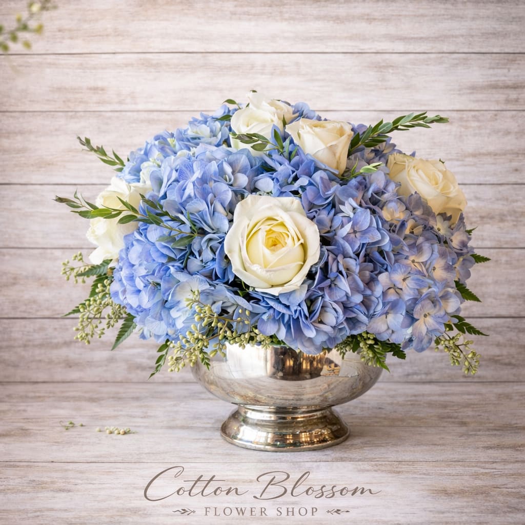 Timeless Elegance - Timeless Elegance – Blue Hydrangea &amp; White Rose Centerpiece in Maricopa, AZ  Make any occasion unforgettable with our Timeless Elegance centerpiece. This refined table arrangement features lush blue hydrangeas paired with graceful white roses, artfully designed in a classic silver bowl. Accented with fresh eucalyptus varieties, this arrangement offers a soft, soothing fragrance and a look of timeless sophistication.  Perfect for weddings, anniversary dinners, sympathy gatherings, dinner parties, corporate events, or simply elevating your home décor, this elegant floral design creates a stunning focal point for any table.  Each arrangement is hand-crafted in Cotton Blossom’s signature style using premium, fresh flowers for a full and balanced presentation.  Cotton Blossom Flower Shop proudly offers same-day flower delivery in Maricopa, Casa Grande, and Stanfield, Arizona. Order online today and bring refined beauty to your next special occasion with your trusted local Maricopa florist.