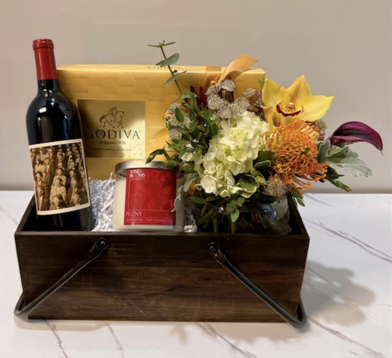 Cabernet Celebration Box - This Luxurious Gift Box includes a bottle of Napa Valley Cabernet, a Premium scented soy candle, a box of delicious Chocolates, and a Designer's choice floral arrangement. Note: Flower varieties and candle scents may vary based on availability. Important: To order wine, both the customer and recipient must be at least 21 years old. Valid ID required upon delivery. By placing an order, you confirm you and the recipient are of legal drinking age.