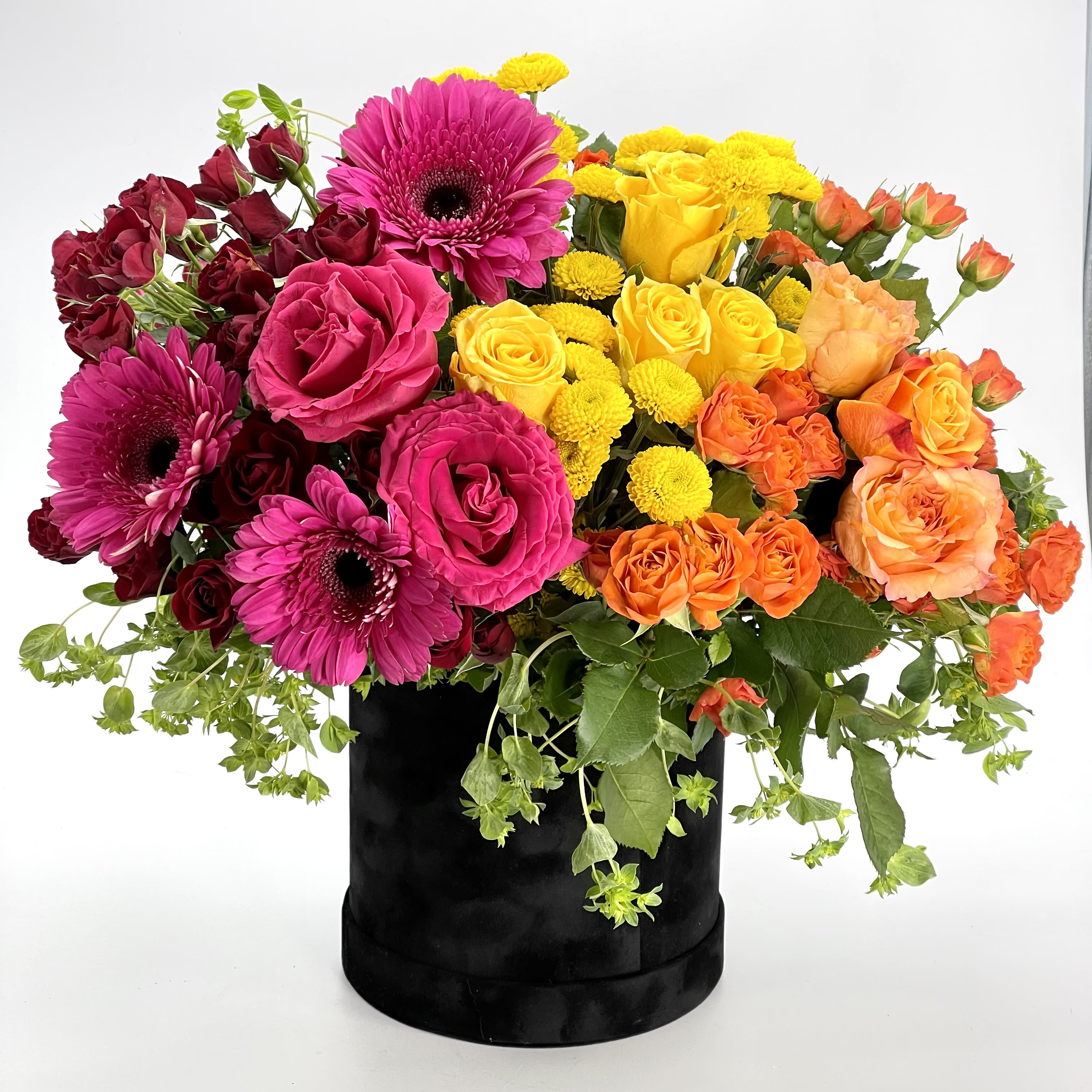Color Burst Bouquet - Put a spring in their step with this Color Burst Bouquet of hot pink, Yellow, Orange Roses, Hot Pink Gerberas, orange, yellow, red Spray roses, with assorted greeneries. Arranged in luxury black Box. A perfect treat for any occasion!