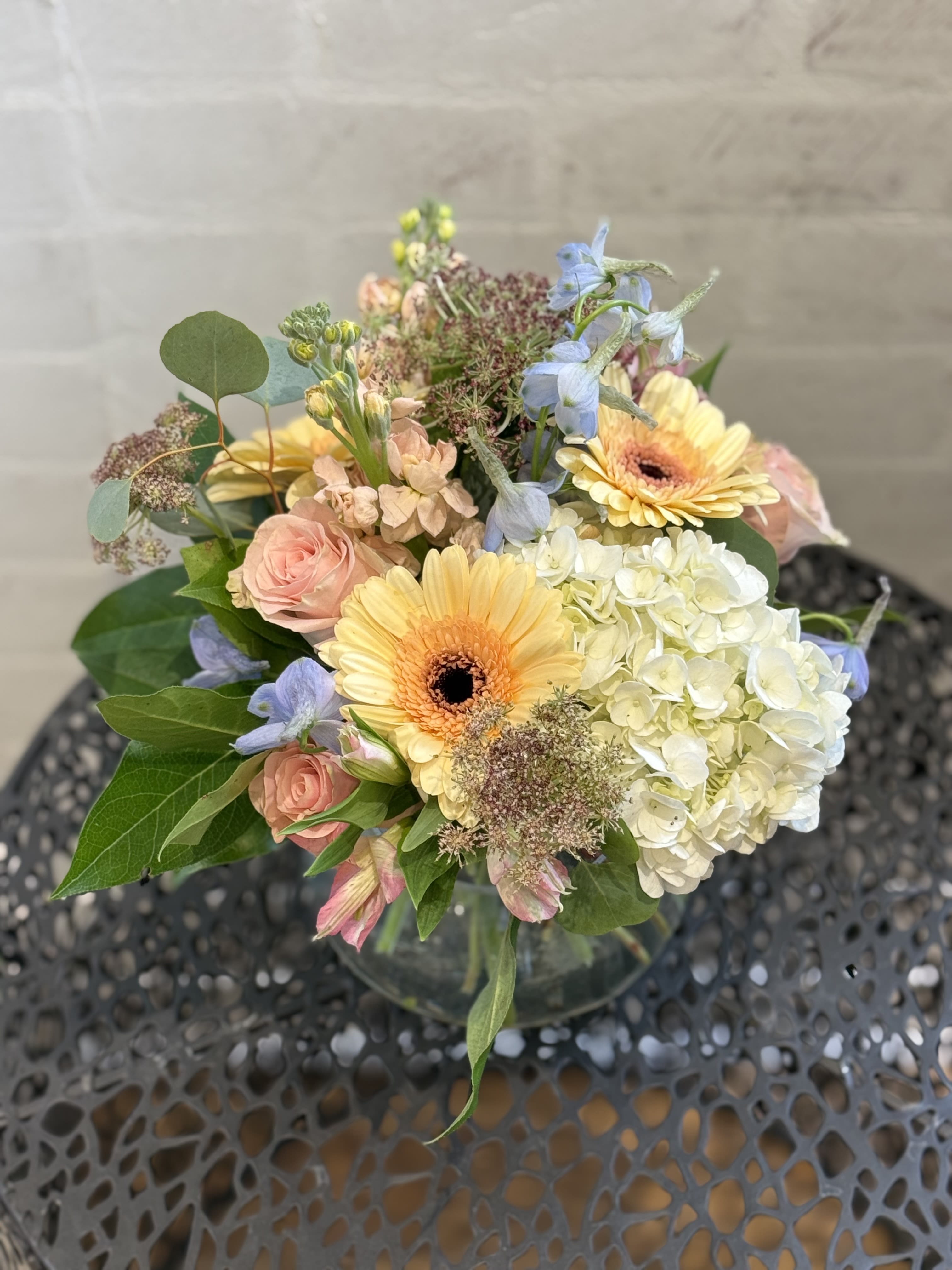New!  Country Romance  - This soft toned arrangement gives all the feels. This low compact design is filled with beautiful floral and fauna in peach, pink, whites and a touch of blue. 