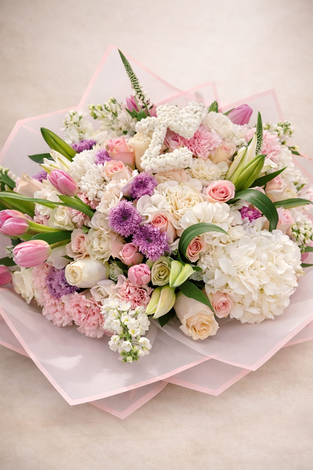 The Grand Romance - A couture-style hand-tied bouquet wrapped in premium pink-edged paper for a refined, modern finish.  This luxurious arrangement features a curated blend of blush and ivory roses, hydrangeas, tulips, lisianthus, carnations, and delicate textural accents. Each stem is thoughtfully layered to create depth, softness, and elevated elegance.  Designed for those who want something unforgettable — perfect for anniversaries, proposals, baby showers, birthdays, or simply to impress.  Handcrafted with intention and signature style by Cactus Flowers. 