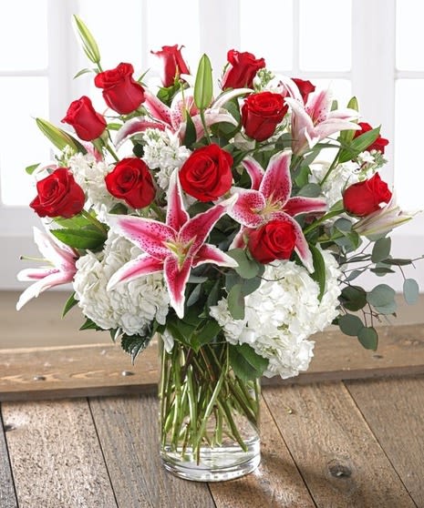 Be my valentine - Long stem red velvet roses with pink stargazer, lilies, and hydrangeas design in a glass clear tall base with greens and baby breath and a nice red ribbon. Perfect for this Valentine’s Day.