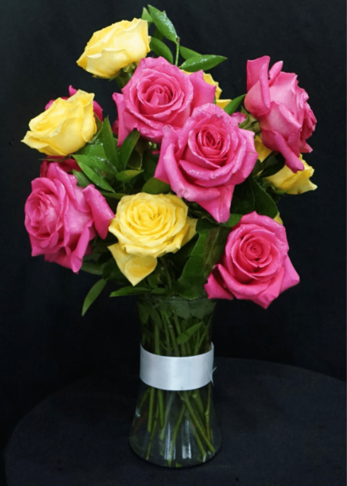"Te Amo"  - For the love of your life. Pink and yellow jumbo roses with a variety of greens like eucalyptus, Ruscus Israel and baby eucalyptus in a 8" clear glass vase, total of 12 beautiful colorful roses. Give us a call or send an email if you would like to choose your color of roses.  Para el amor de tu vida. Rosas jumbo rosadas y amarillas con una variedad de verdes como eucalipto, Ruscus Israel y eucalipto bebé en un jarrón de vidrio transparente de 8", total de 12 hermosas rosas coloridas. Llámenos o envíe un correo electrónico si desea elegir su color de rosas. 