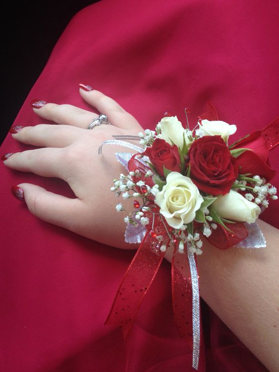 Hand corsage with red and white roses on a red dress