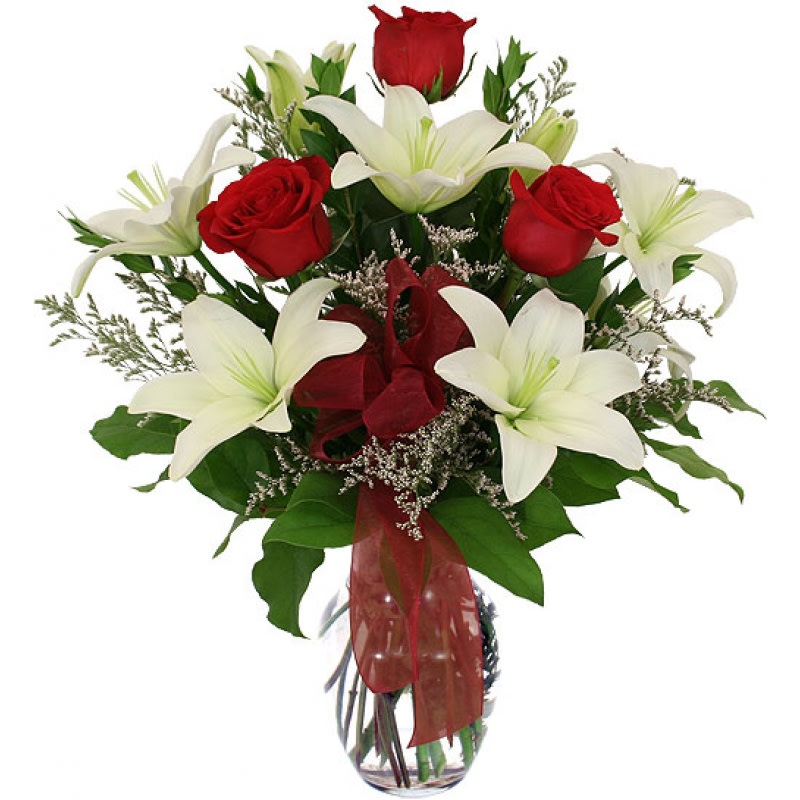 Bouquet of red roses and white lilies in a glass vase