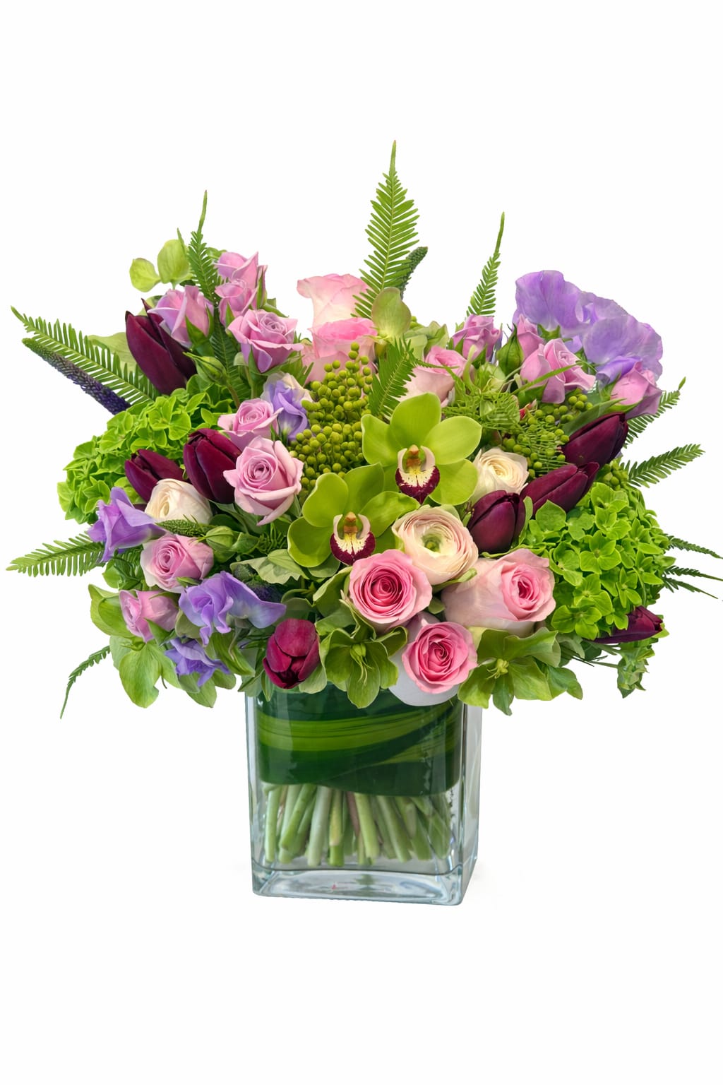 Lime - A lush, garden-style arrangement featuring soft pink roses and ranunculus, vibrant green cymbidium orchids with burgundy centers, and deep purple mini calla lilies. Accented with green hydrangea, sweet peas, and layered seasonal foliage, the bouquet is designed in a clear glass vase for a fresh, modern look with rich texture and depth.