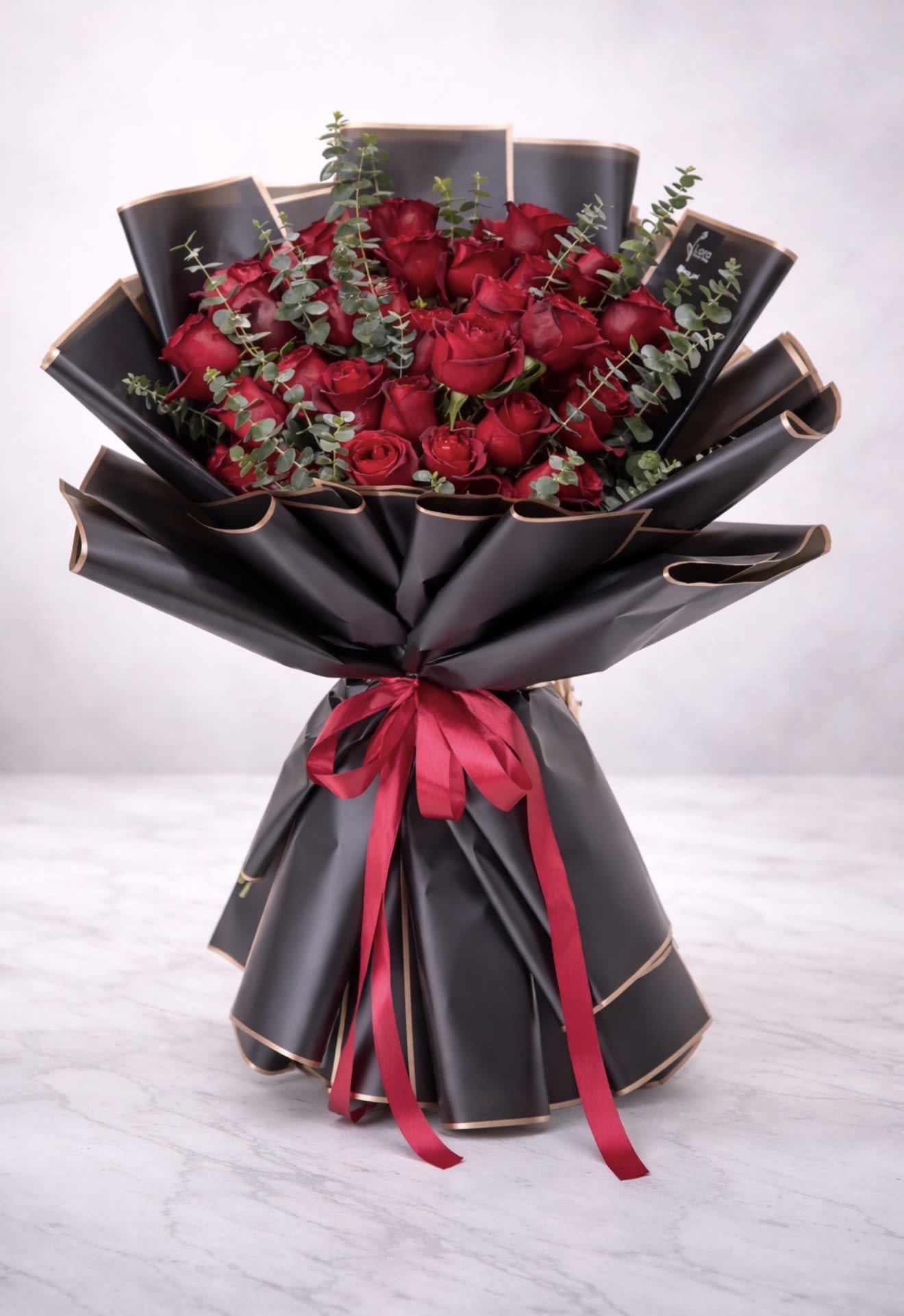 Luxury Red Rose Bouquet  - Make a powerful statement with our Midnight Romance Rose Bouquet, featuring premium long-stem red roses beautifully wrapped in sophisticated black designer paper with gold edging. Accented with fresh eucalyptus and tied with a rich satin ribbon, this bouquet embodies elegance, passion, and modern luxury.  Perfect for anniversaries, Valentine’s Day, proposals, birthdays, or grand romantic gestures, this arrangement is handcrafted by AZ Flowers &amp; Gifts and available for same-day flower delivery in Alpharetta, GA 30022 and surrounding areas.  Order luxury red roses in Alpharetta today and surprise someone with a bold and unforgettable floral experience.