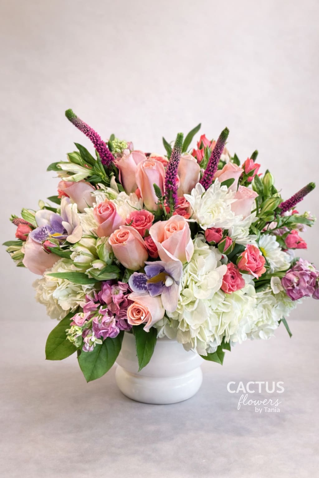 Tania Blush Garden - This elegant garden-style arrangement features soft blush roses, delicate spray roses, white hydrangeas, seasonal blooms and fresh greenery, beautifully designed in a classic white vase.  Romantic, refined, and thoughtfully arranged, Rosé Elegance is perfect for birthdays, anniversaries, thank-you gestures, or simply to brighten someone’s day.  Handcrafted with care and signature style by Cactus Flowers by Tania.