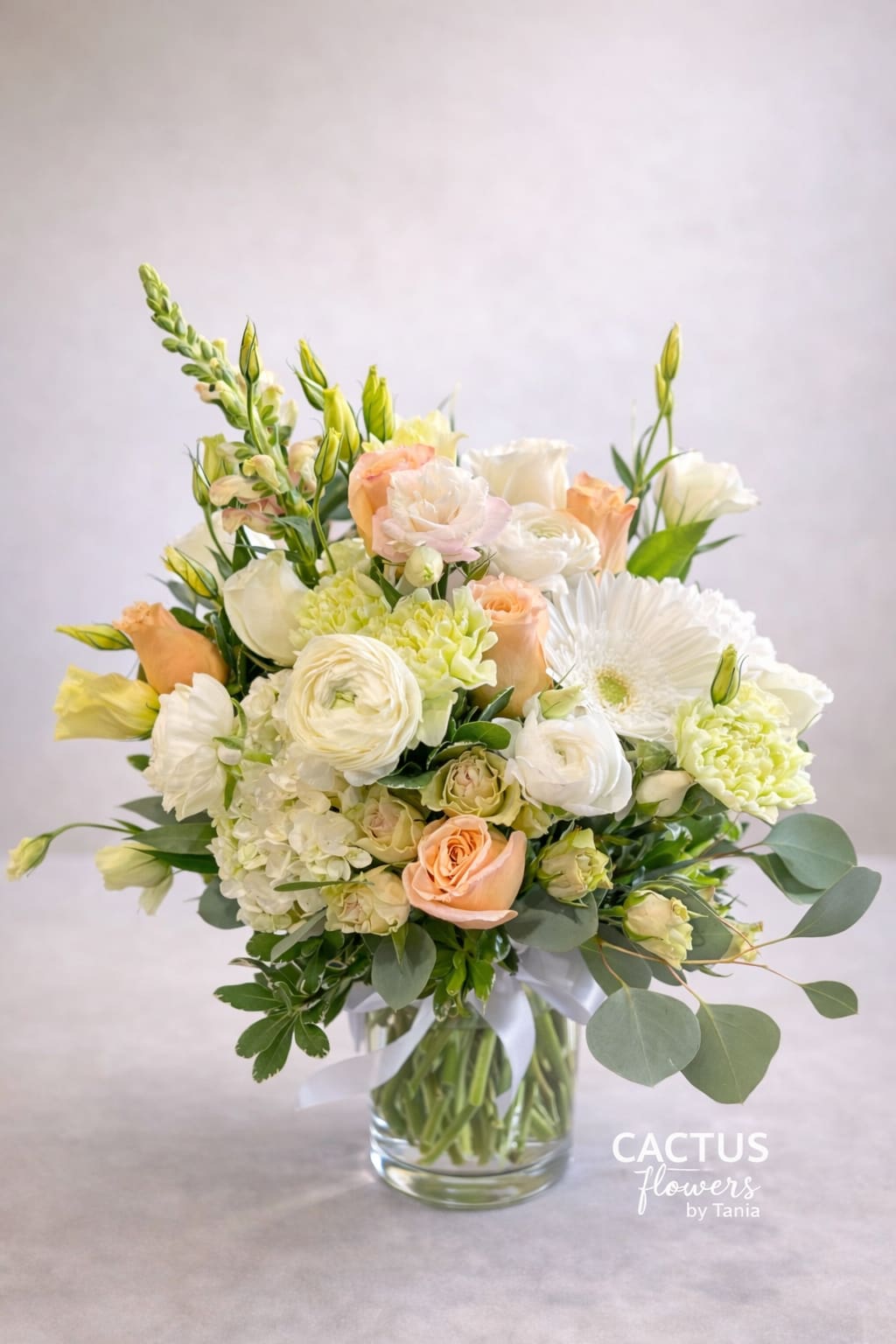 Blush &amp; Ivory Garden - Soft peach roses, creamy hydrangea, ranunculus, lisianthus and seasonal premium blooms designed in a clear glass vase with elegant greenery accents.  A fresh and sophisticated arrangement perfect for birthdays, celebrations, or simply to brighten someone’s day with timeless beauty. 