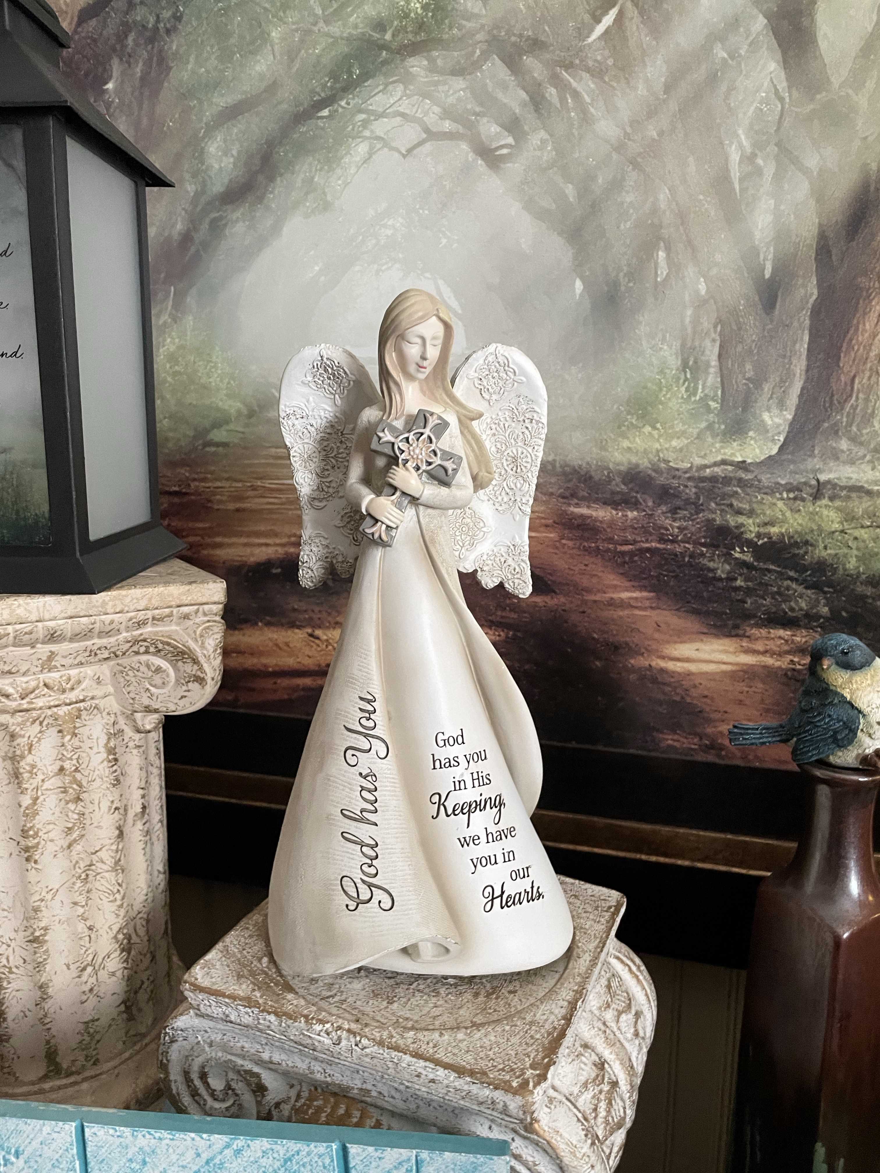 God has You Angel - White resin wood carved angel figurines. Angels have brown hair and are wearing long white dresses and are holding a cross, inscribed with verse.  