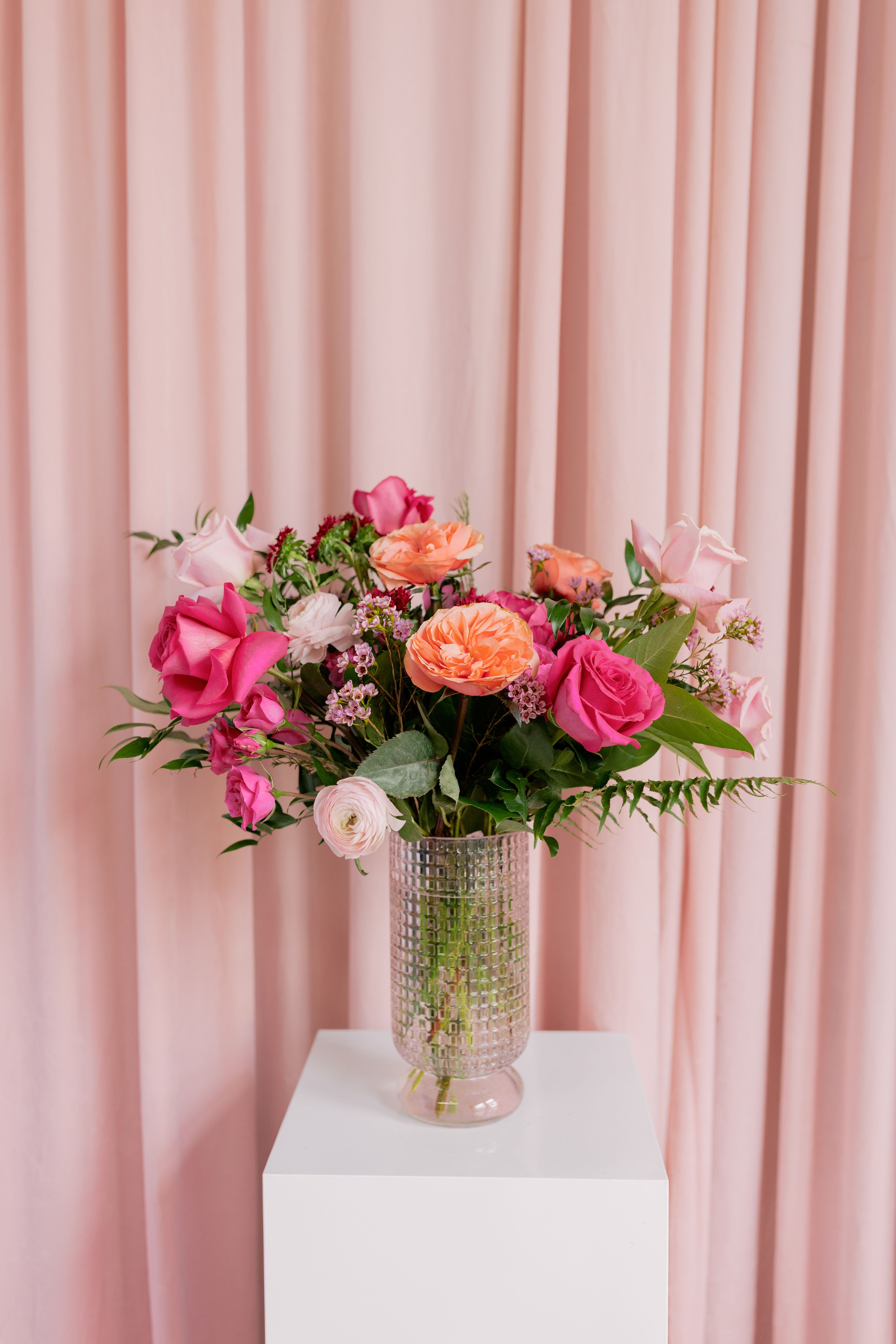 Love Story - Soft, elegant, and full of charm — this pale pink dimpled vase showcases a curated selection of romantic blooms. Designed to create a full, garden-inspired look, this arrangement makes a beautiful statement for anniversaries, birthdays, or simply celebrating someone special. A timeless expression of sweetness and love in every petal.