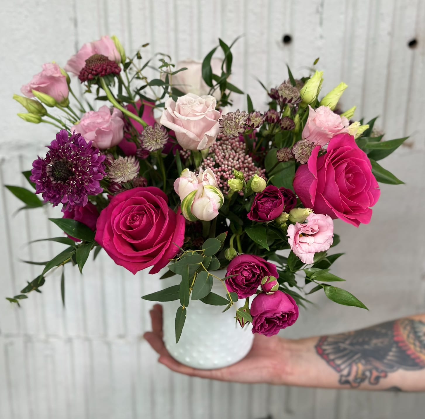 Pink and purple rose bouquet in a white vase