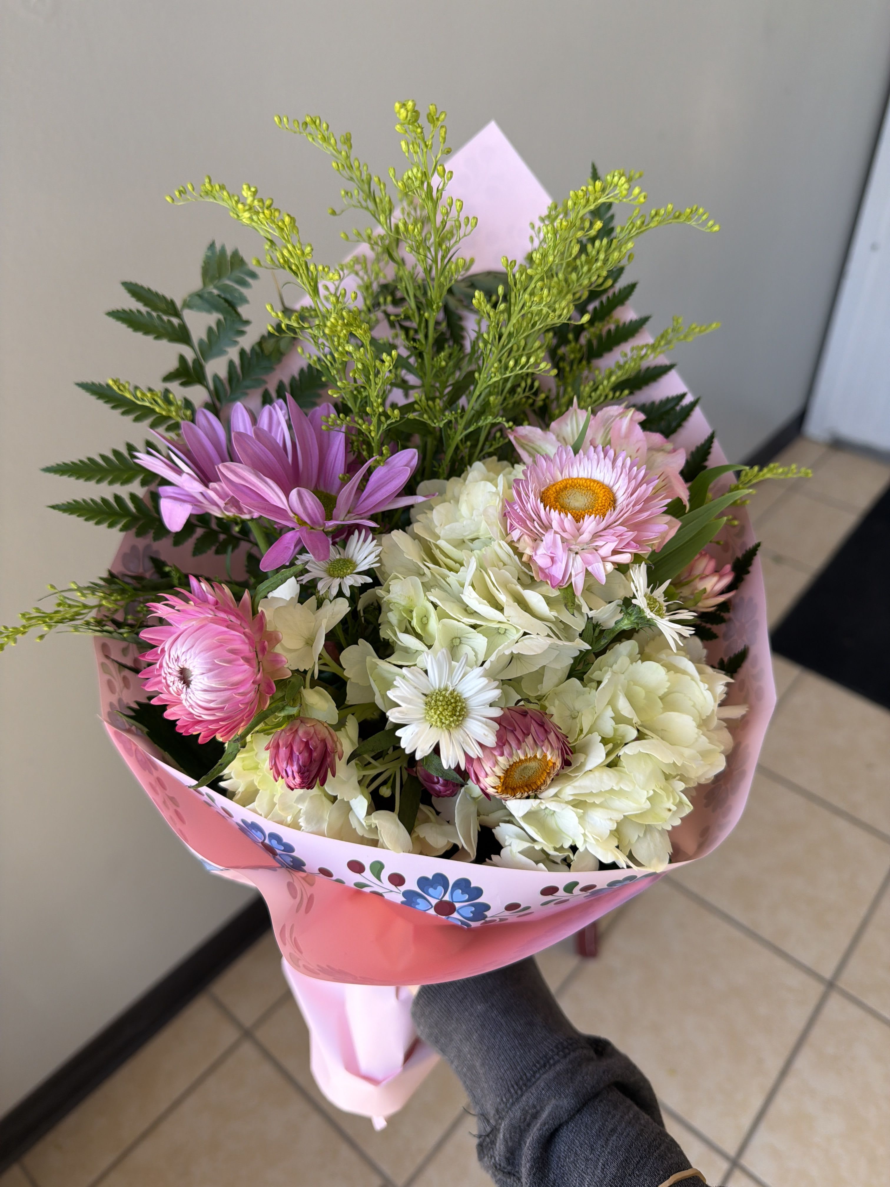 mini wildflower - small assortment of strawflower, hydrangeas, alstroemerias, solidago, and daisies with a leather leaf stem.