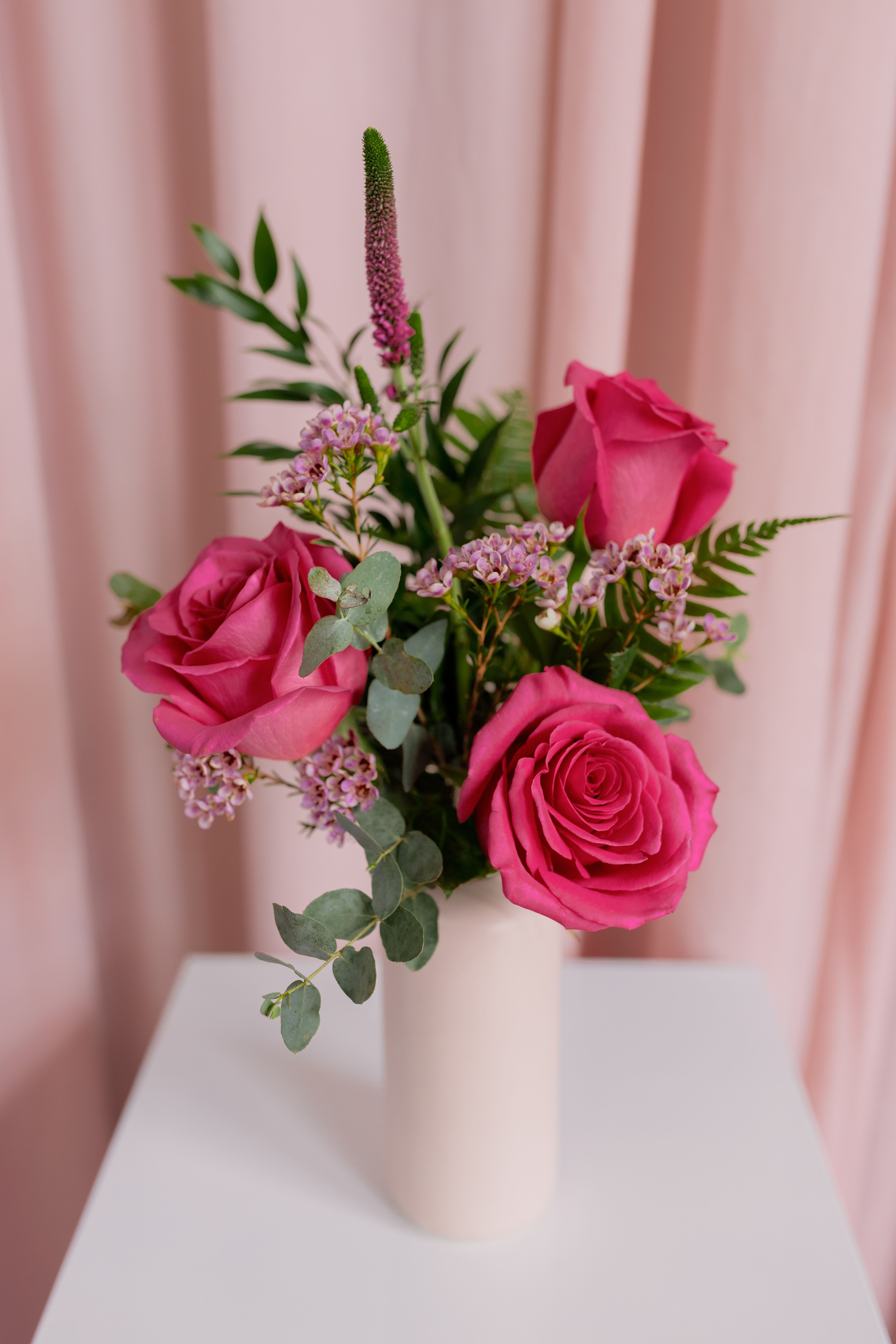 Hot Romance - Delicate, charming, and effortlessly elegant — this petite arrangement features pink roses accented with fresh greenery and airy filler blooms. Designed in a classic vase, it’s the perfect little gesture for birthdays, thank-yous, anniversaries, or just because. A beautiful reminder that the simplest blooms can say the sweetest things.