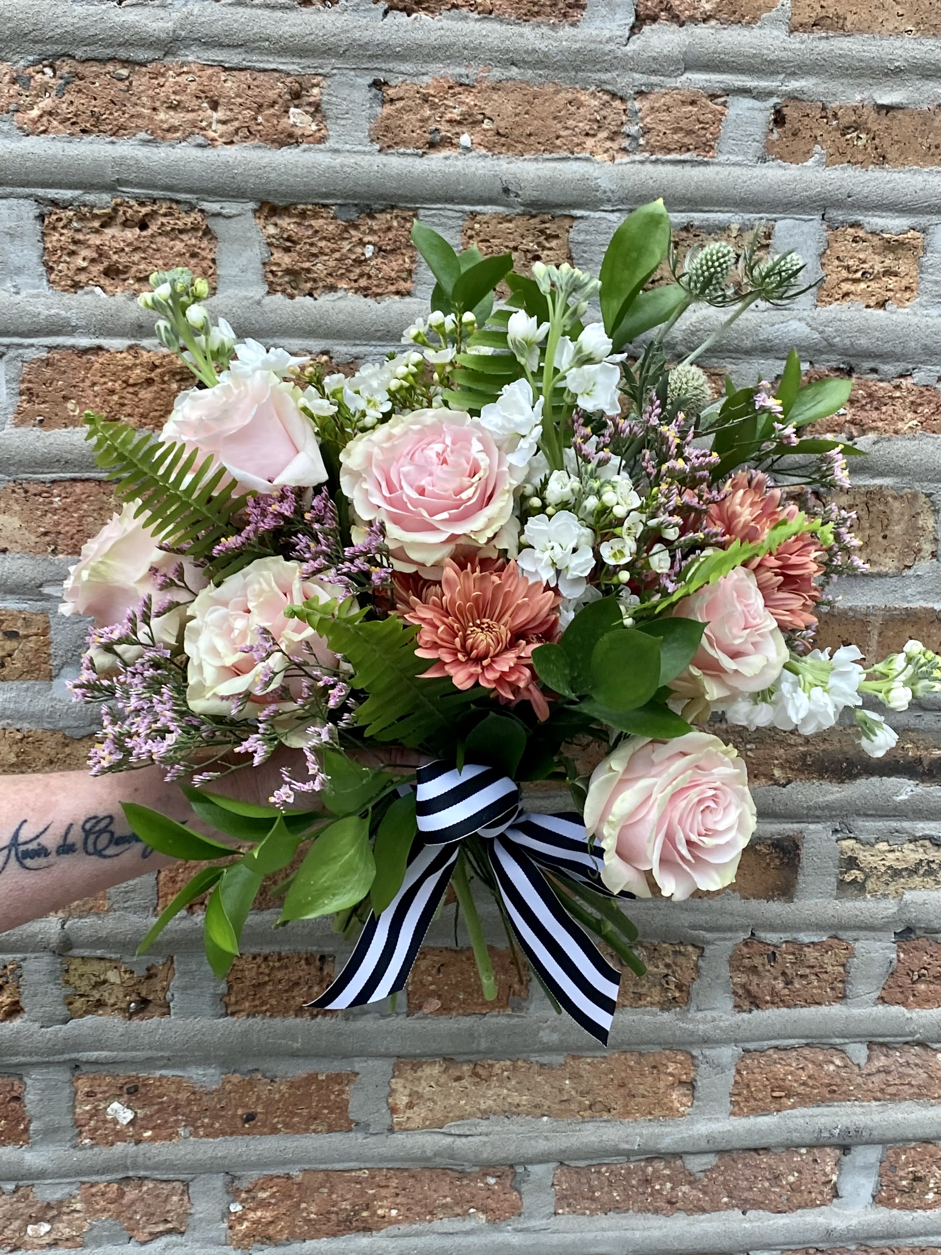 AMOUR Hand Tied Bouquet - Not Available Week of Valentines - Soft Pink Roses, Coral Spray Mums, White Stock, Accent florals and greens in a wildflower style bouquet.   COLORS MAY VARY SLIGHTLY