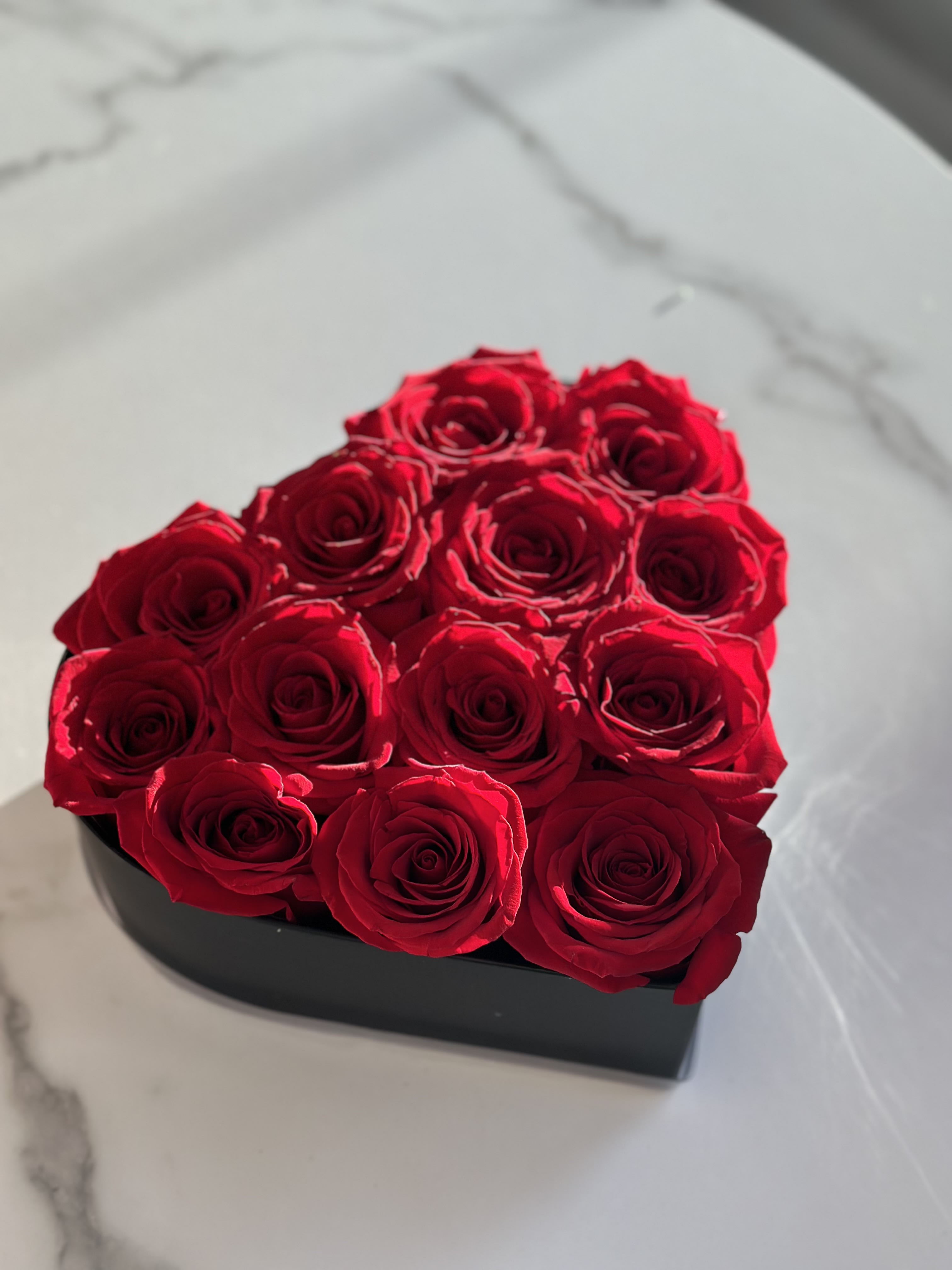 My Heart in Red  - A black heart-shaped box filled with roses.   Flower types may vary depending on the season.