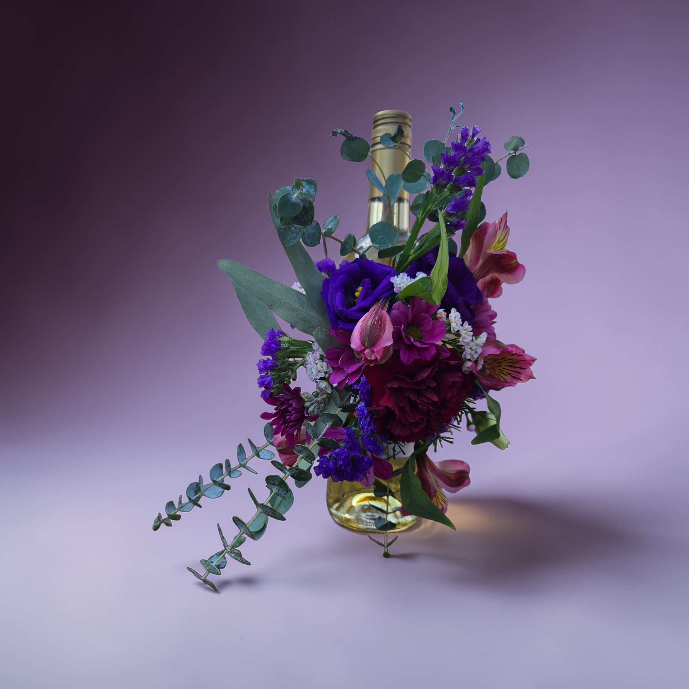 Flower adorned wine bottle - This 2 in1 gift features a petite centerpiece, along with a choice of wine, champagne or non-alcoholic beverage. Just remove the flowers and place on a dish. Voile 2 gifts in one!