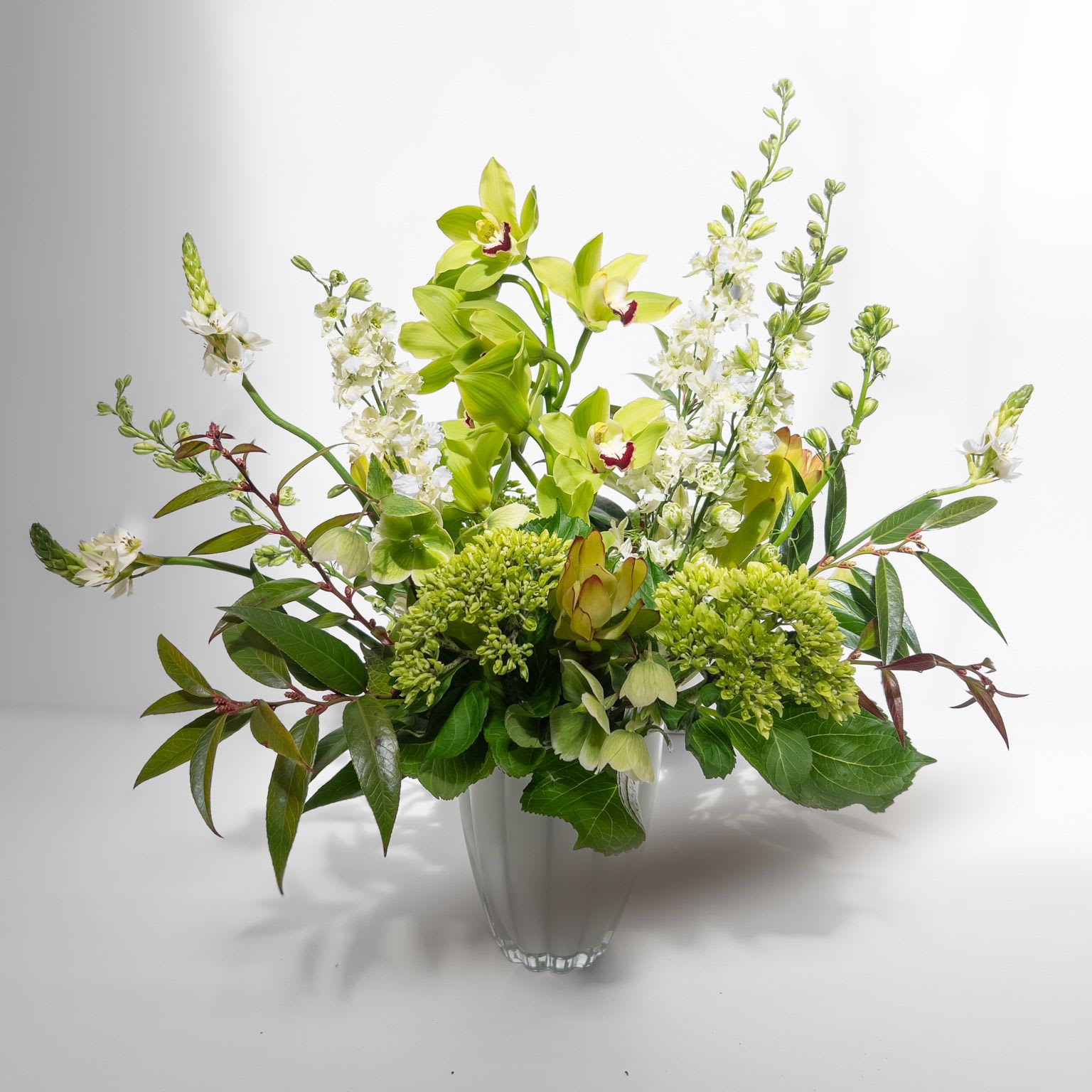 Fields of Green - This verdant arrangement highlights the striking beauty of cymbidium orchids, bringing an organic and untamed elegance to any space. Perfect for nature lovers and those drawn to an effortlessly chic, botanical aesthetic. 