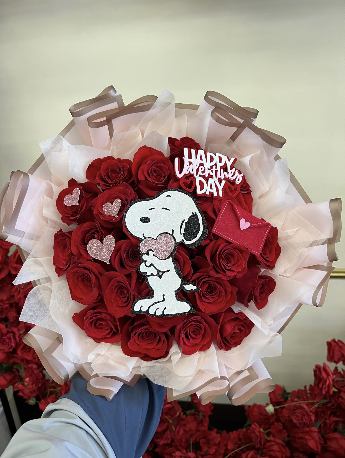 Snoopy Valentines Buchon - A classic Valentine’s bouquet featuring rich red roses, wrapped in a soft blush pink paper for a sweet contrast. Finished with our handmade Diana’s Flowers glitter cardstock Snoopy cutout, perfect for Snoopy lovers and anyone who loves a little charm with their roses.