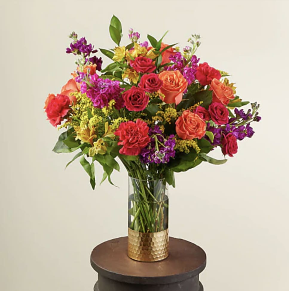 Sundance Bouquet - A lovely balance of dainty and bold, our Sundance Bouquet is the perfect arrangement for all celebrations. Filled with the most striking blooms of the season like hot pink and orange roses, this adorable bouquet shines with delicate yellow solidago stems to compliment the bright colors.
