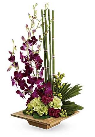 Tall orchid arrangement with bamboo and green hydrangeas in a wooden base