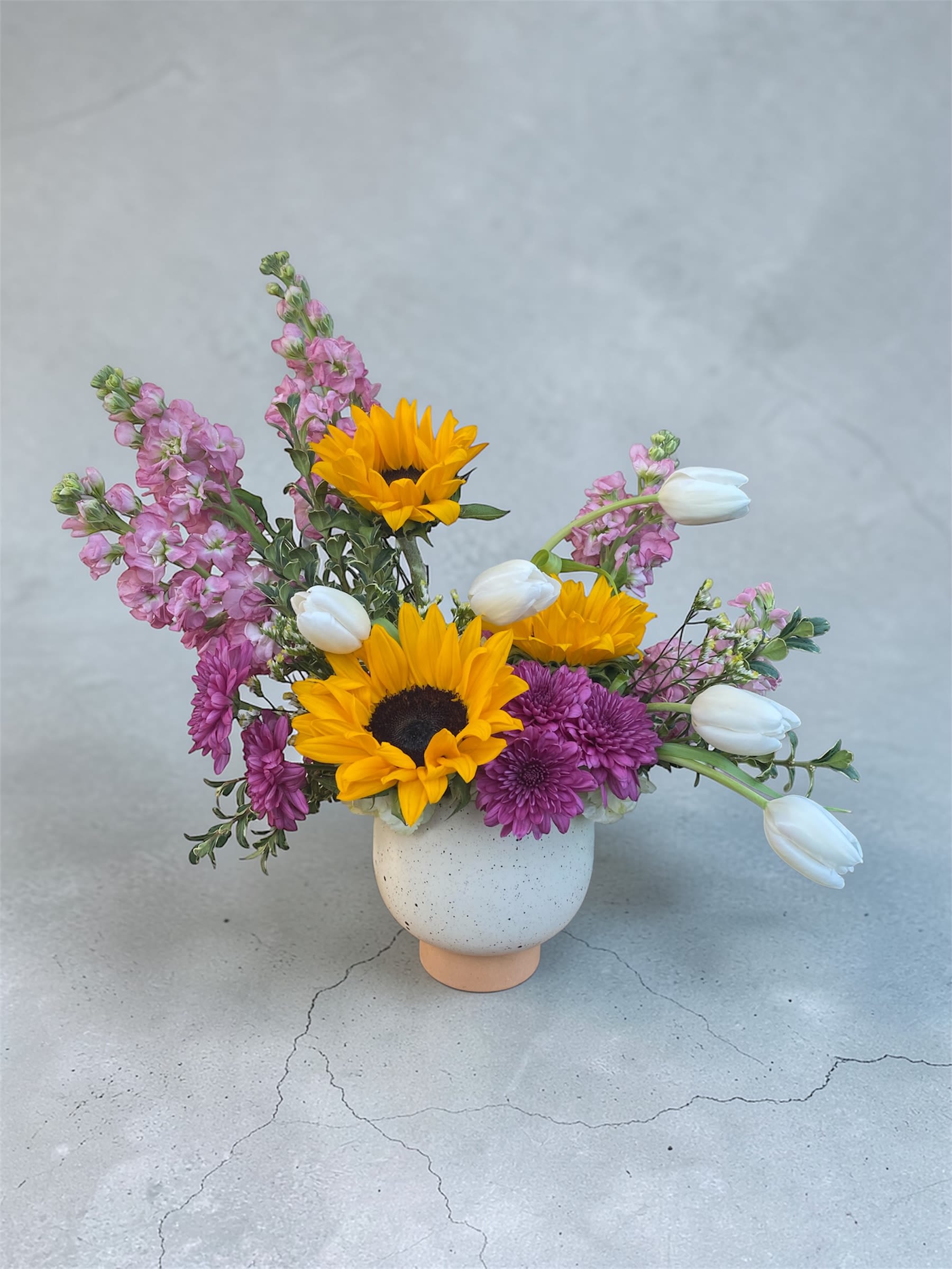Touch of Spring  - A fun fragrant spring arrangement filled with sunflowers, stock, sweet tulips and more.  