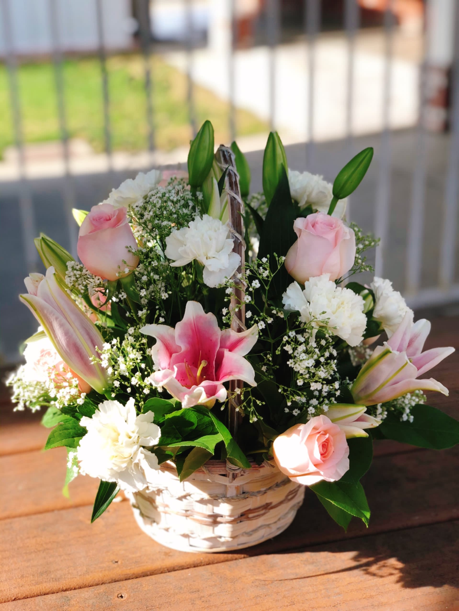 Spring Basket - - 6 Light pink Roses - 6 White Carnations - 3 Stems Pink Lilies - White Fillers - 8 Inches Basket 