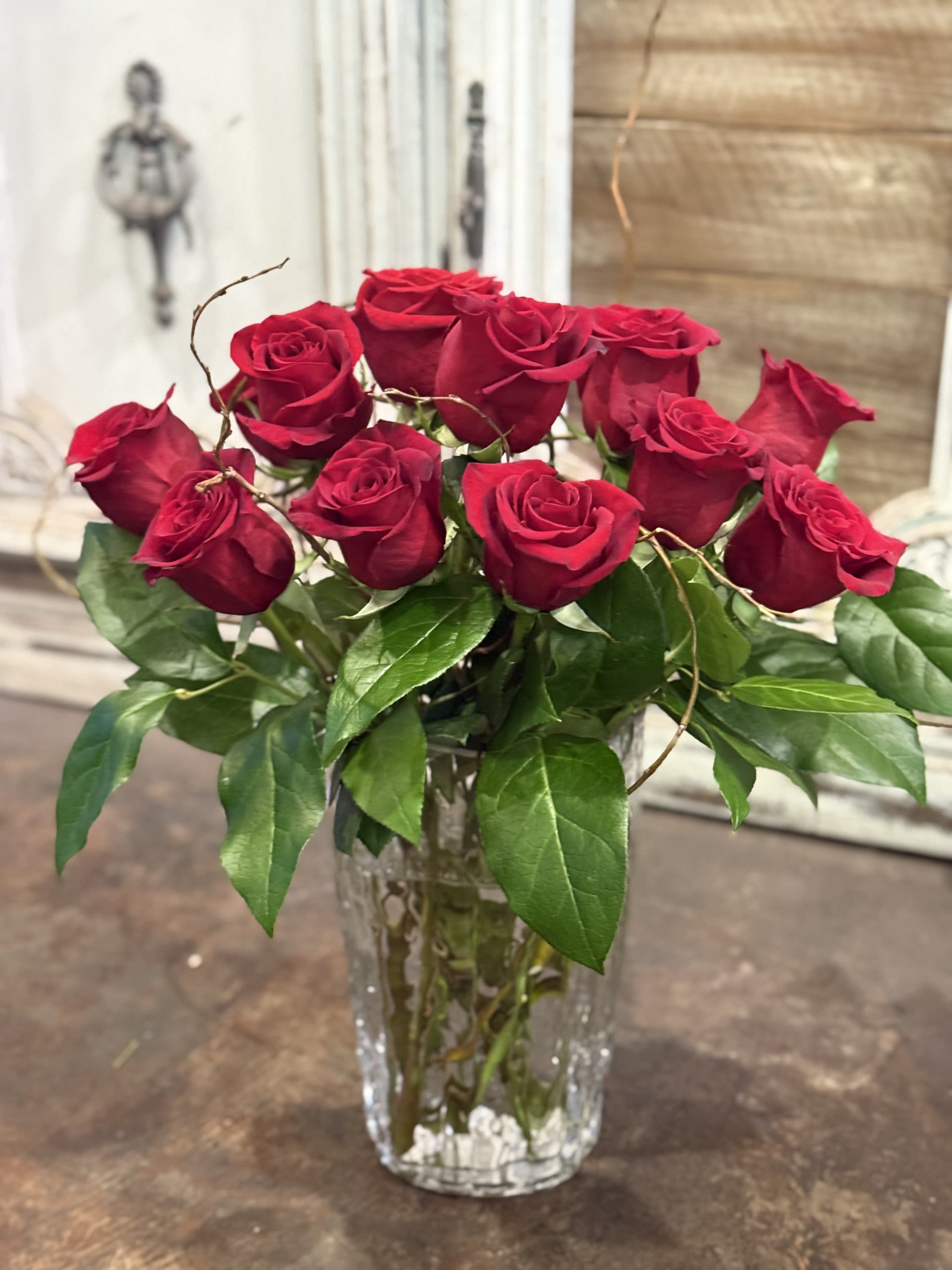 Velvet Flame   - A timeless bouquet of rich red roses accented with delicate white blossoms and lush greenery, beautifully arranged in a textured glass vase. Elegant and romantic, perfect for anniversaries, Valentine’s Day, or expressing heartfelt love.