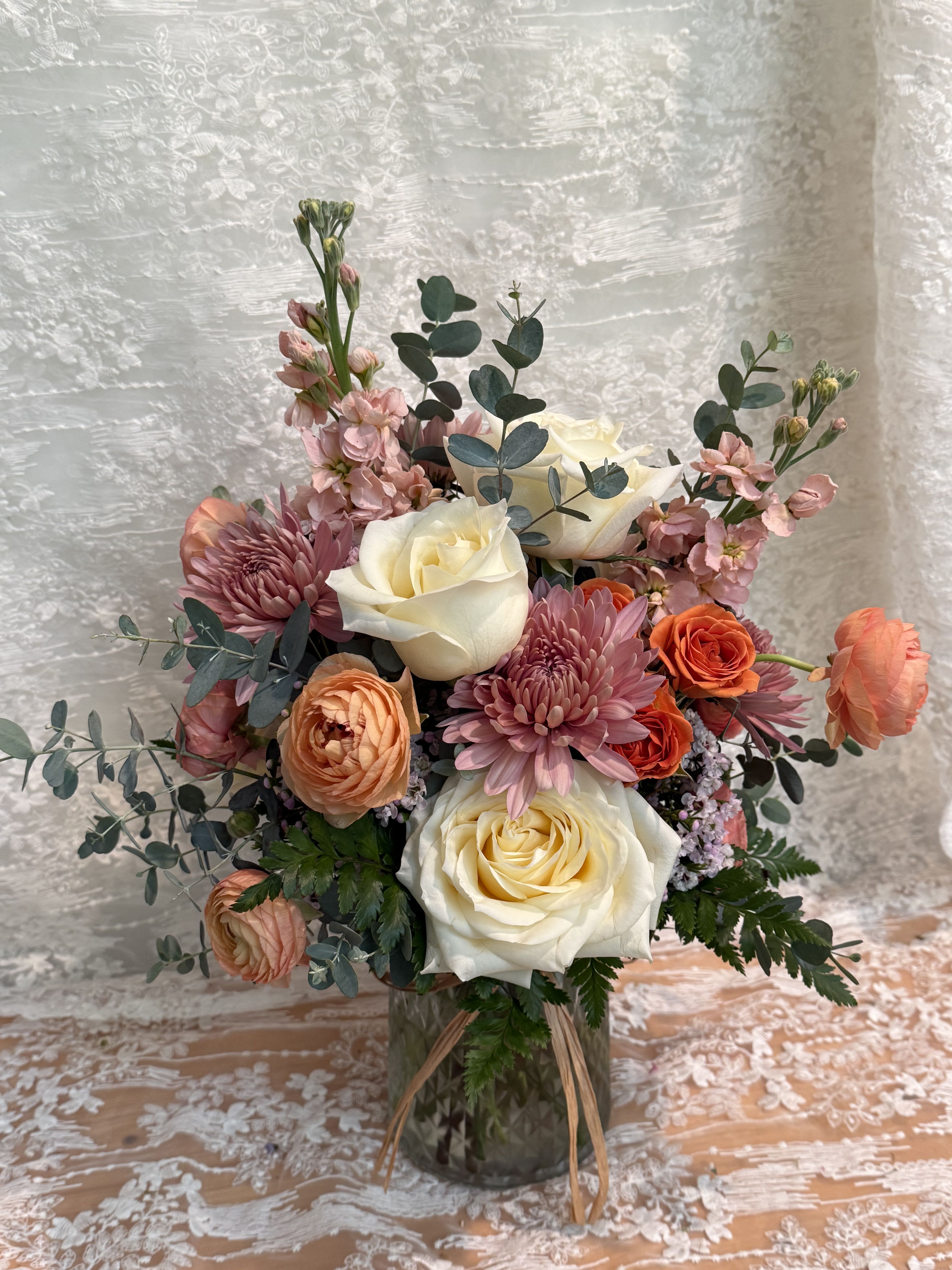 Peach Perfection - Neutral color arrangement filled with cream roses, orange ranunculus, peach stock and eucalyptus 