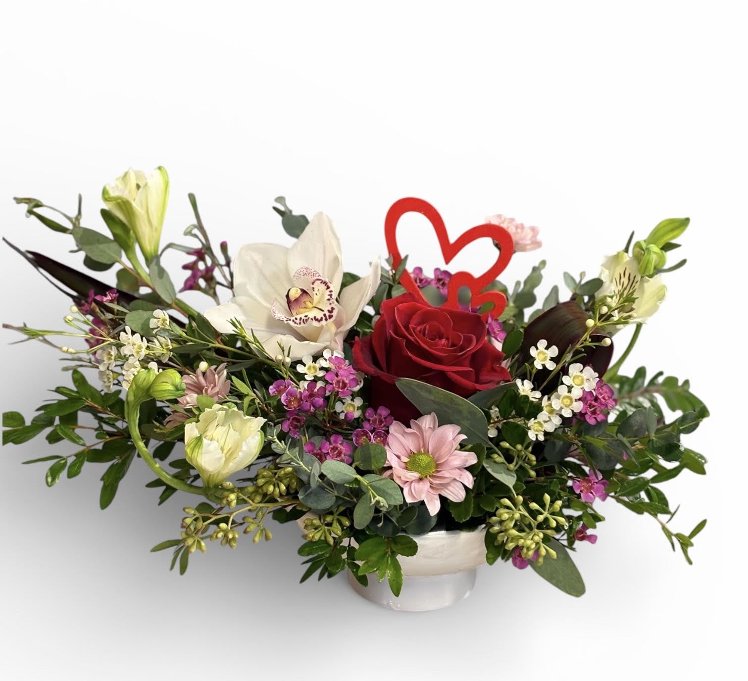 Petite Heart Compote -  A small, intimate compote arrangement featuring a single  red rose paired with a delicate orchid (or a small heart-shaped accent) set in a shallow compote for a focused, romantic statement.